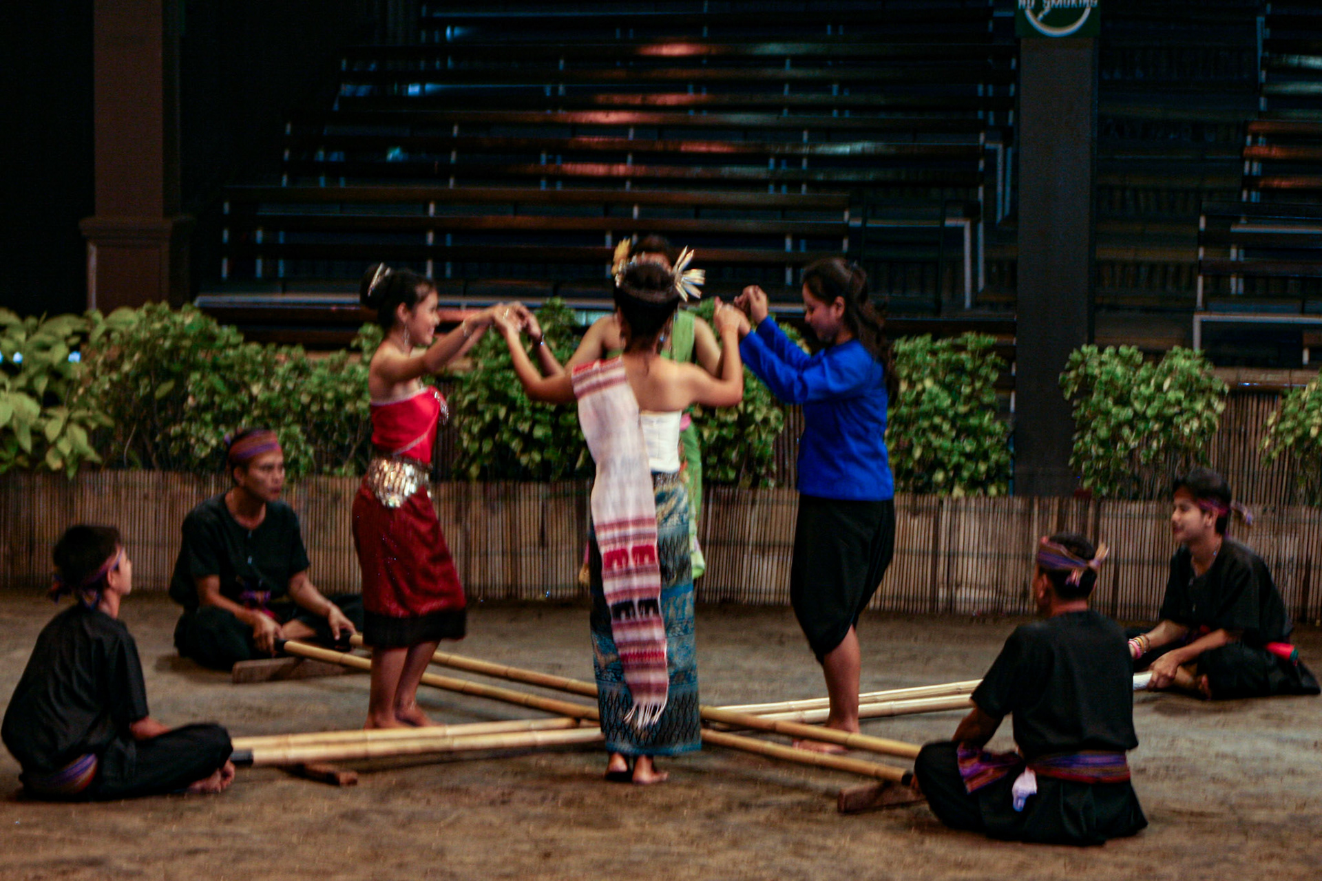 Thai men and women perform the energetic Bamboo Dance of northeastern Thailand at the Rose Garden