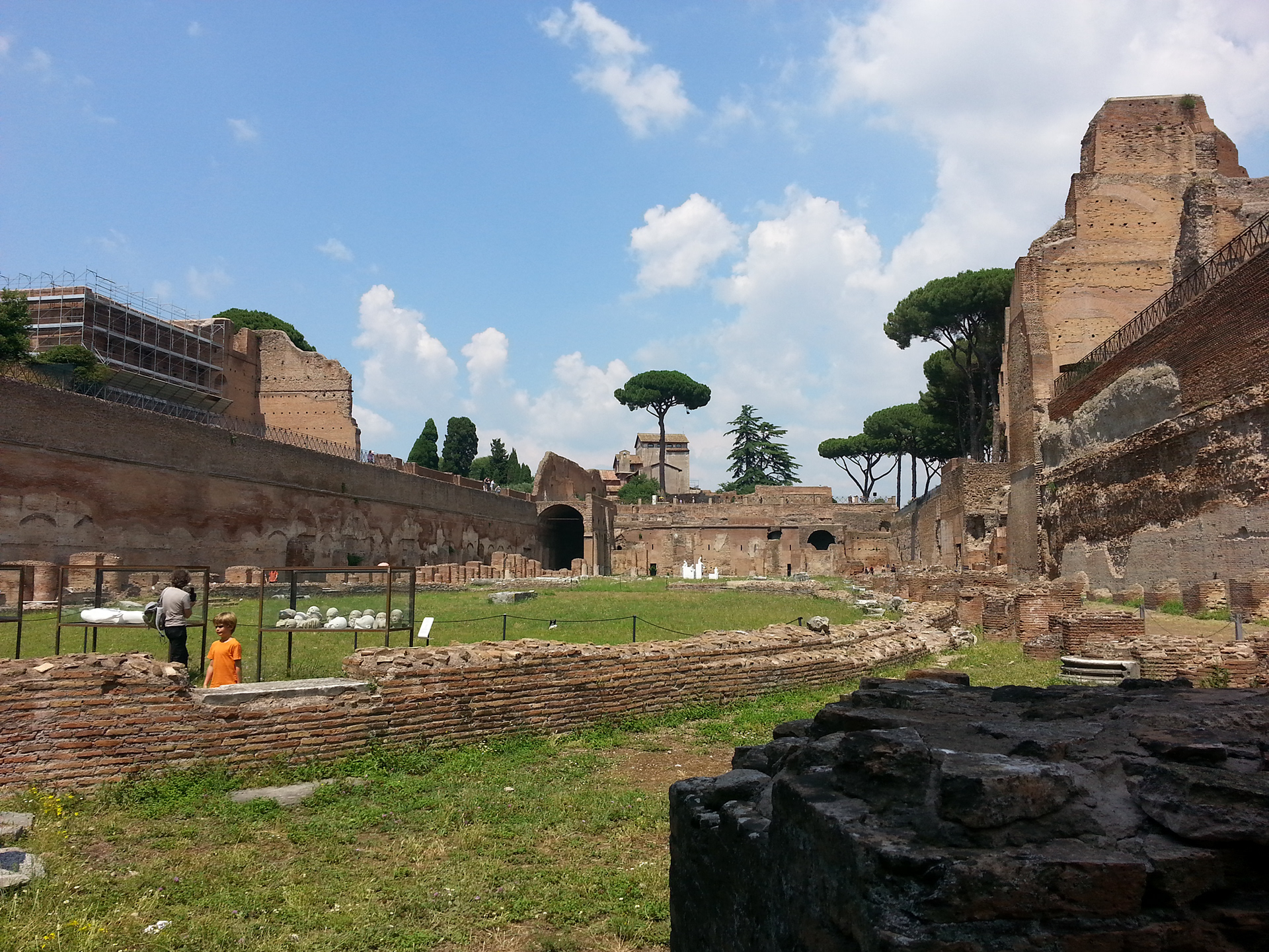 The Palatine Stadium was the third part of Domitian's palace on the Palatine Hill in Rome. It was the last to be built, after the Domus Flavia and the Domus Augustana, respectively the public and private parts of the complex. The stadium was a circus -shaped building, with a very elongated rectangle with a curved shorter side (the southern one) of about 160 x 48 meters. It occupies the entire eastern side of the Domus Augustana, for a total of about 88 meters. The perimeter was decorated by a two-story portico, composed on the lower level by brick pillars covered with marble (only the bases remain) and on the upper level by marble columns, as can be seen in part in the reconstruction of the northern corner. 