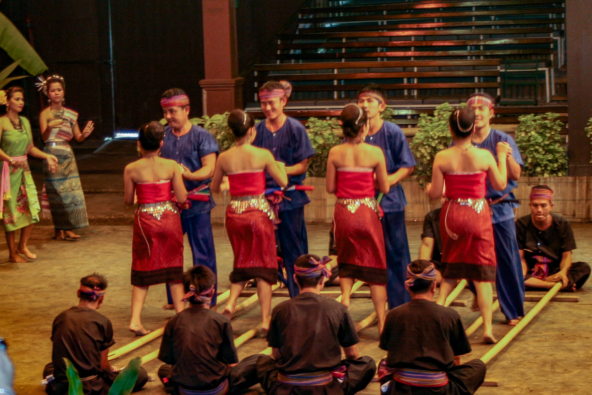 Thai men and women perform the energetic Bamboo Dance of northeastern Thailand at the Rose Garden