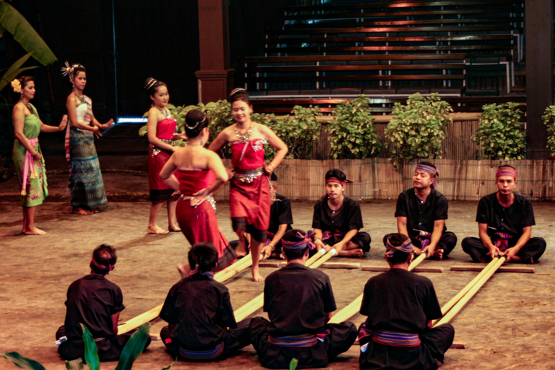 Thai men and women perform the energetic Bamboo Dance of northeastern Thailand at the Rose Garden