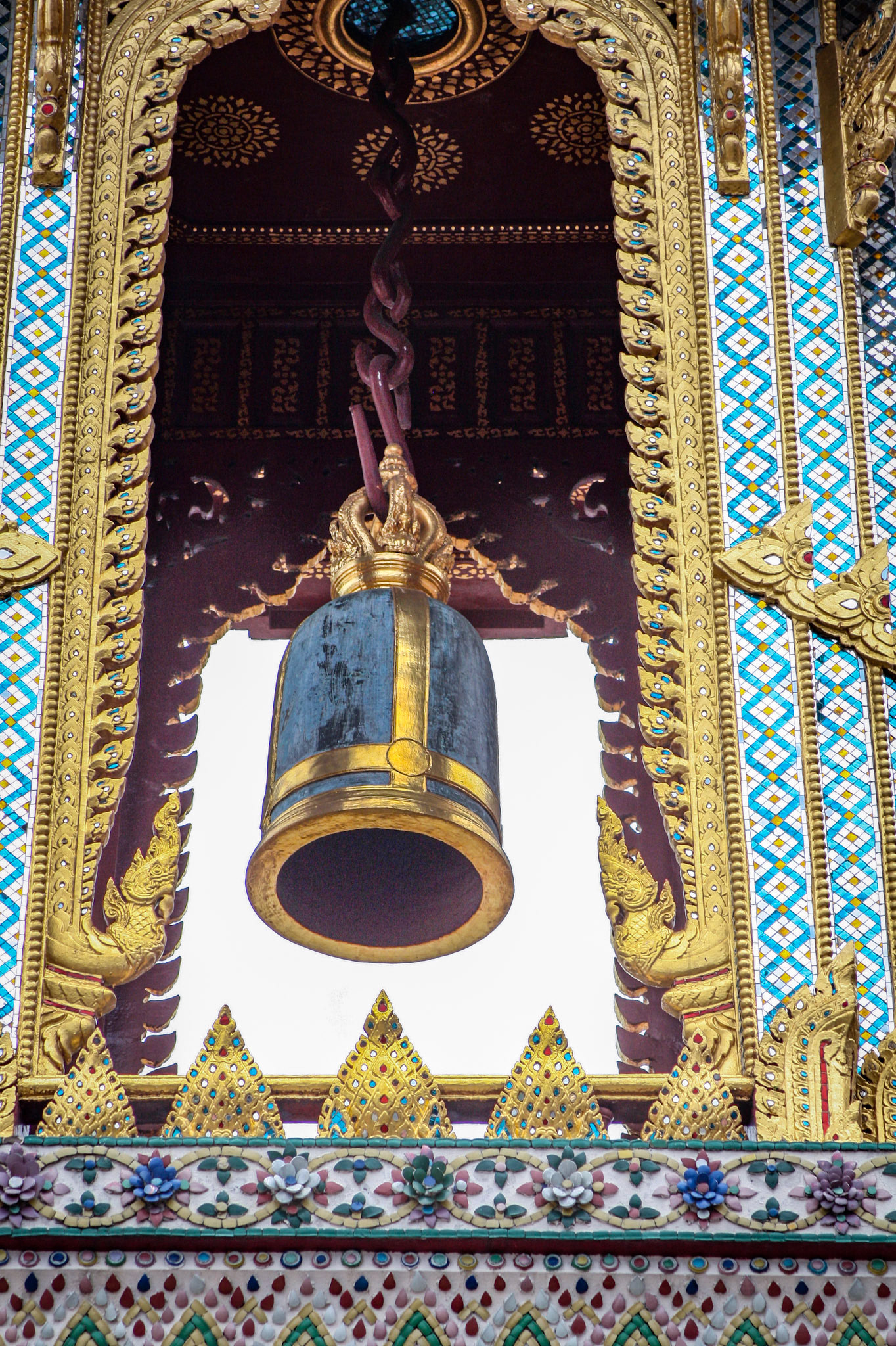 A Thai traditional bell tower (belfry) with detailed, mosaic artwork and gold colored design at Wat Phra Kaew (Temple of the Emerald Buddha) at the Grand Palace