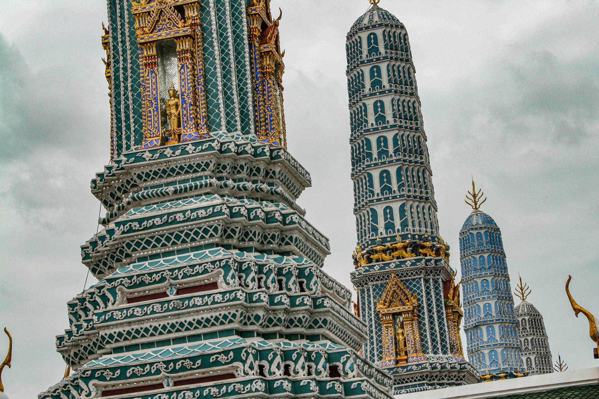 Four Towers Called Prangs or Chedi at Grand Palace in Bangkok, Thailand - These four towers are half of the eight chedis called Phra Atsada Maha Chedis at the eastern side of the Grand Palace. The prangs are ornately decorated with glazed tiles. Their three tiers represent hell, humanity and Nirvana. Each of these prangs also connote a different Buddhist concept. 