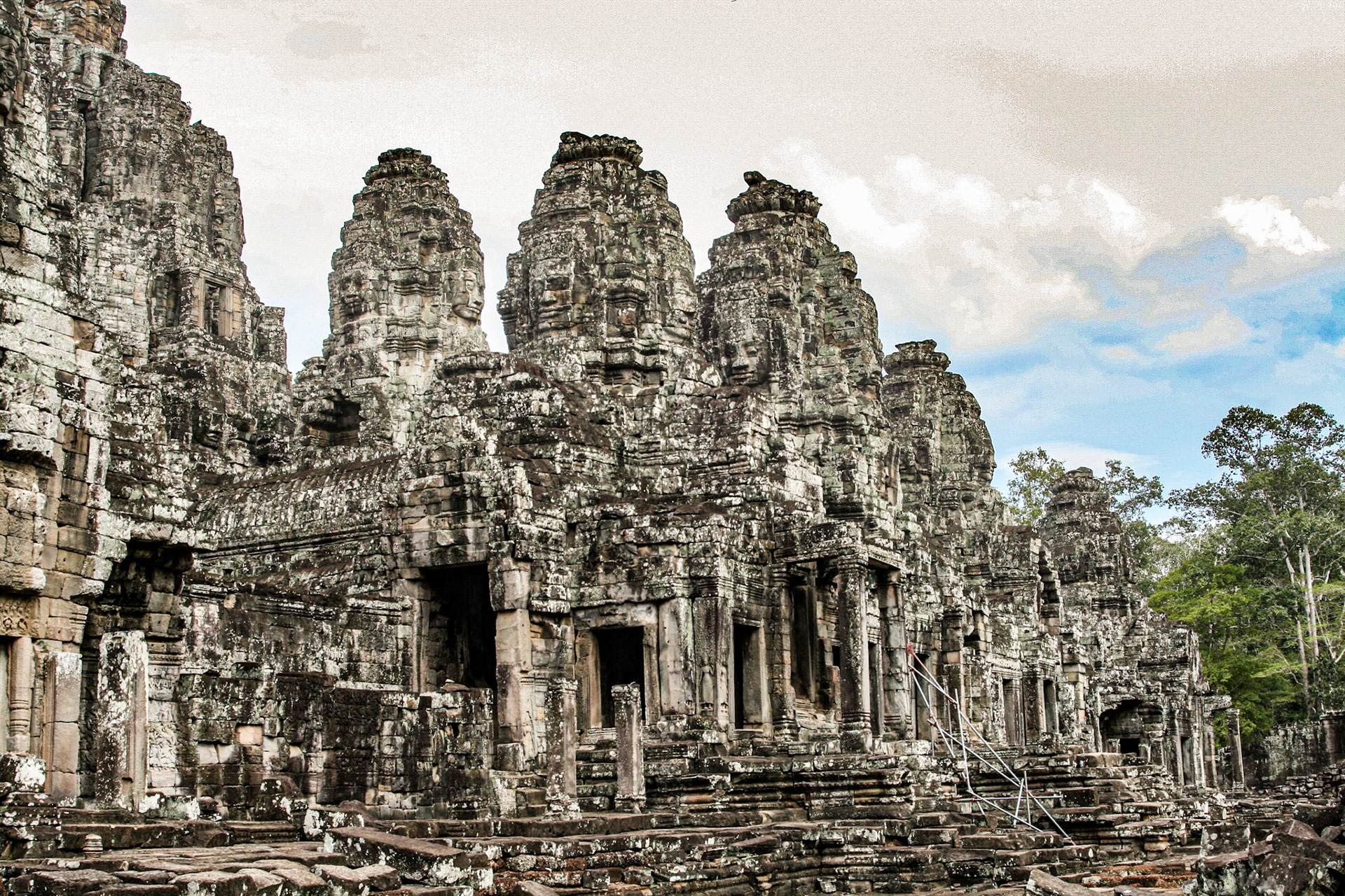 The Bayon's most distinctive feature is the multitude of serene and smiling stone faces on the many towers which jut out from the upper terrace and cluster around its central peak. 