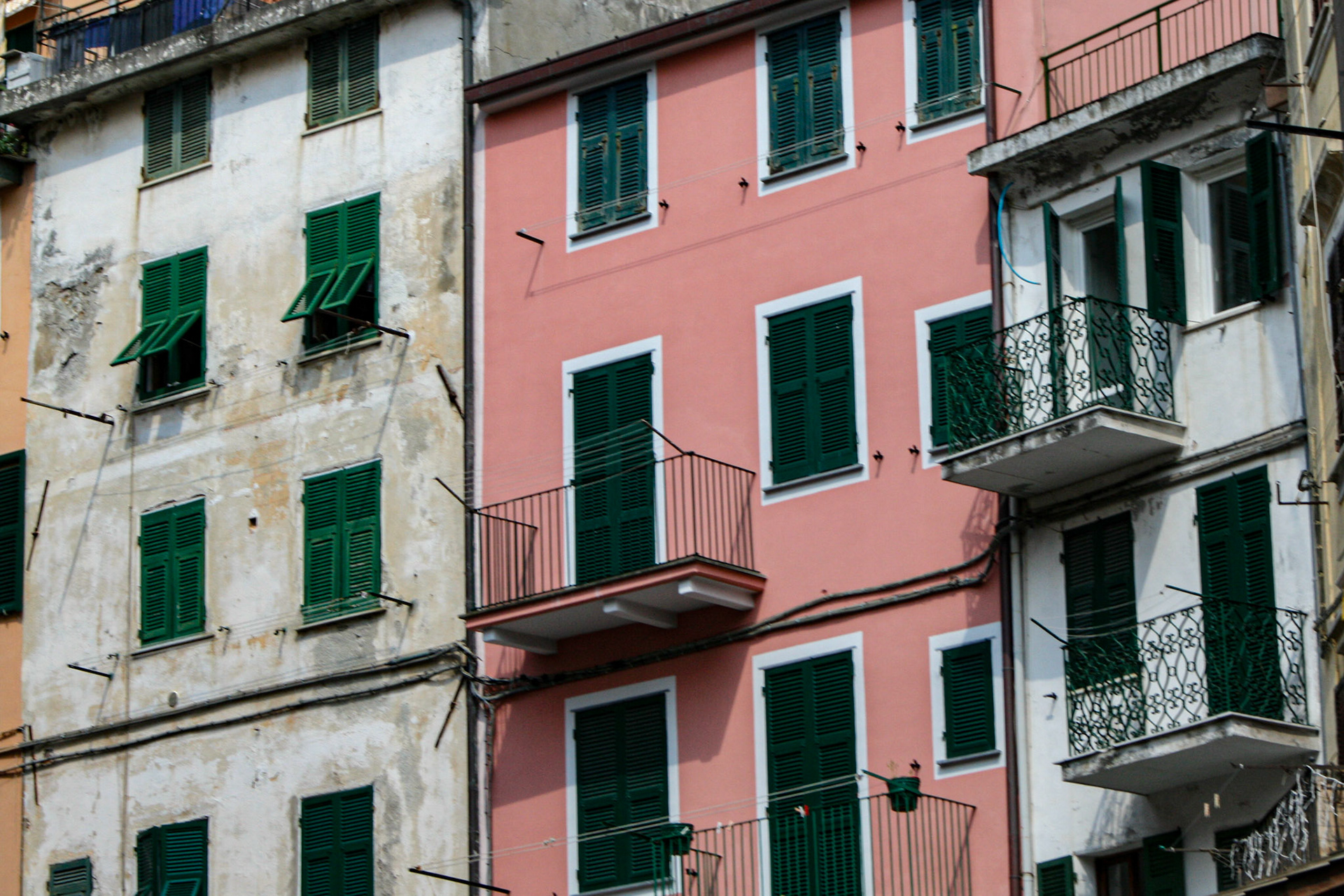 Green shutters add a sense of balance to the bright building colors in the region.