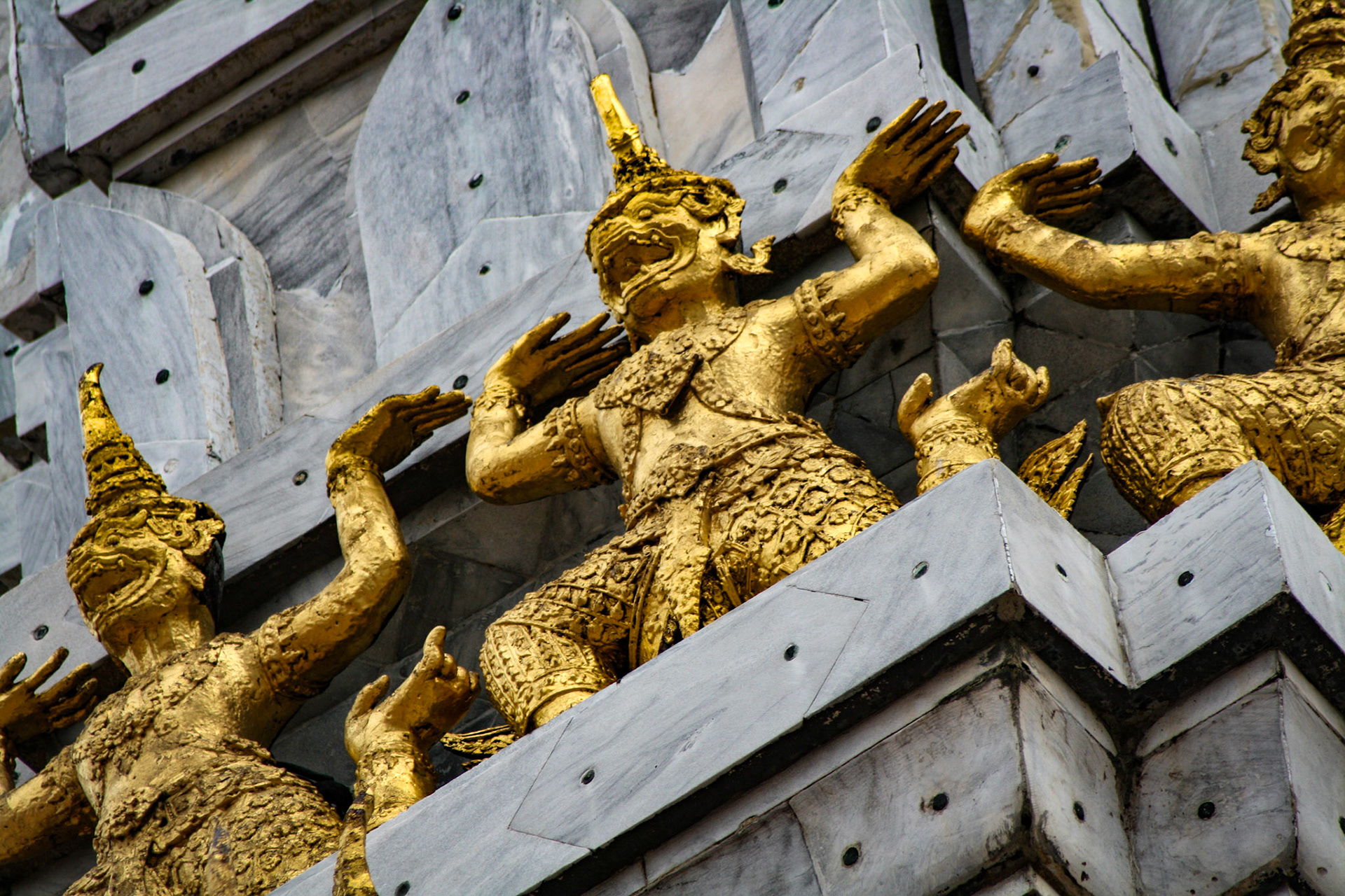 These stupas are different because they are covered in marble and they have gold leaf Khmer style statues.