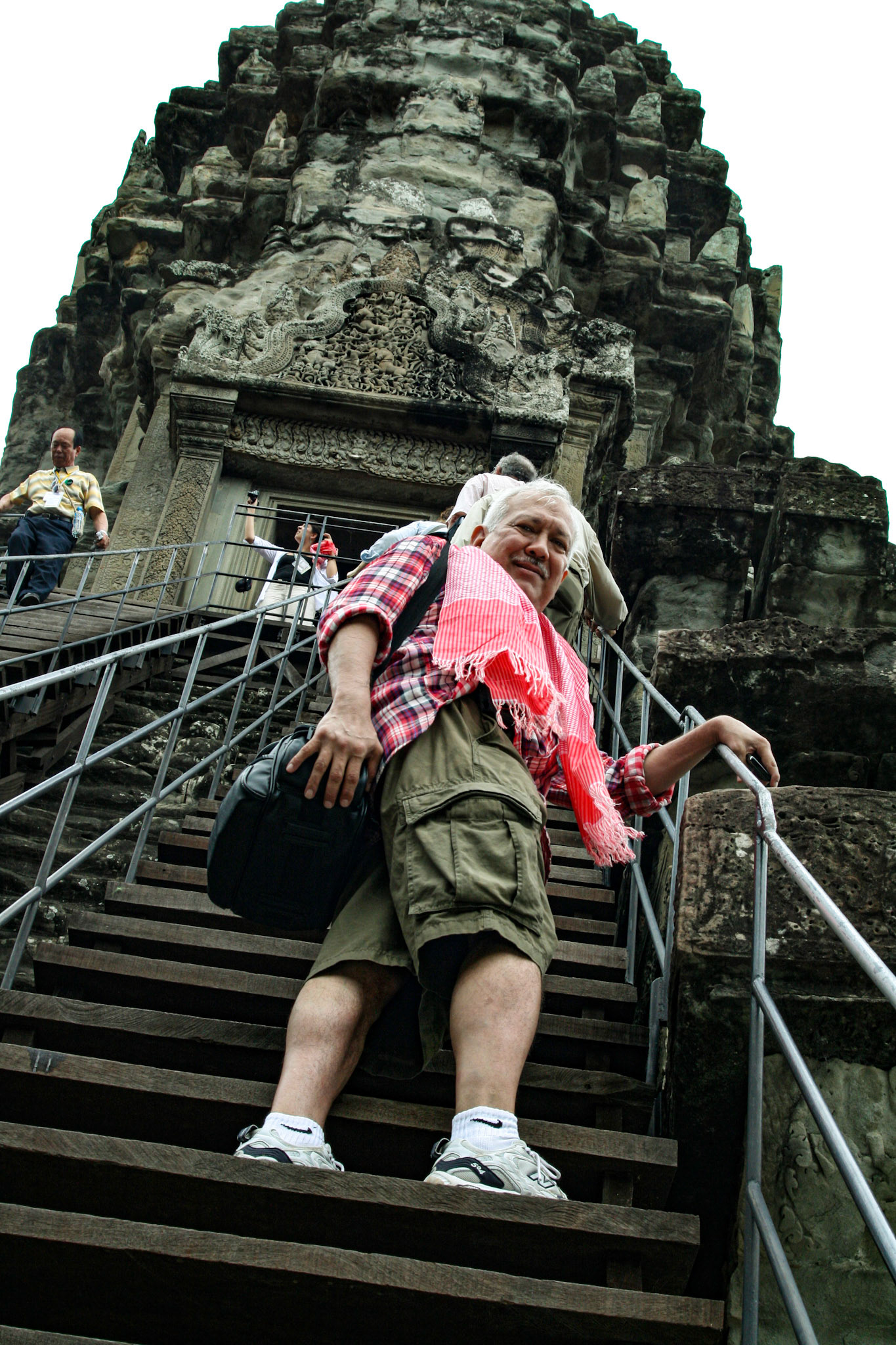 Sam Luna makes the steep climb up into the temple at Angkor Wat. Bakan - The Principal Sanctuary of Angkor Wat. The summit of Angkor Wat's central temple, the highest of temple's three galleries and the uppermost point of world's largest religious complex. 