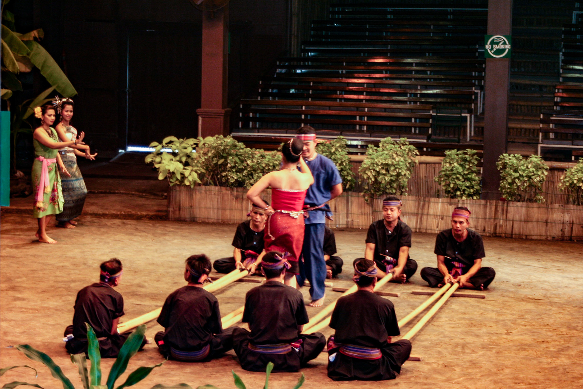 Thai men and women perform the energetic Bamboo Dance of northeastern Thailand at the Rose Garden