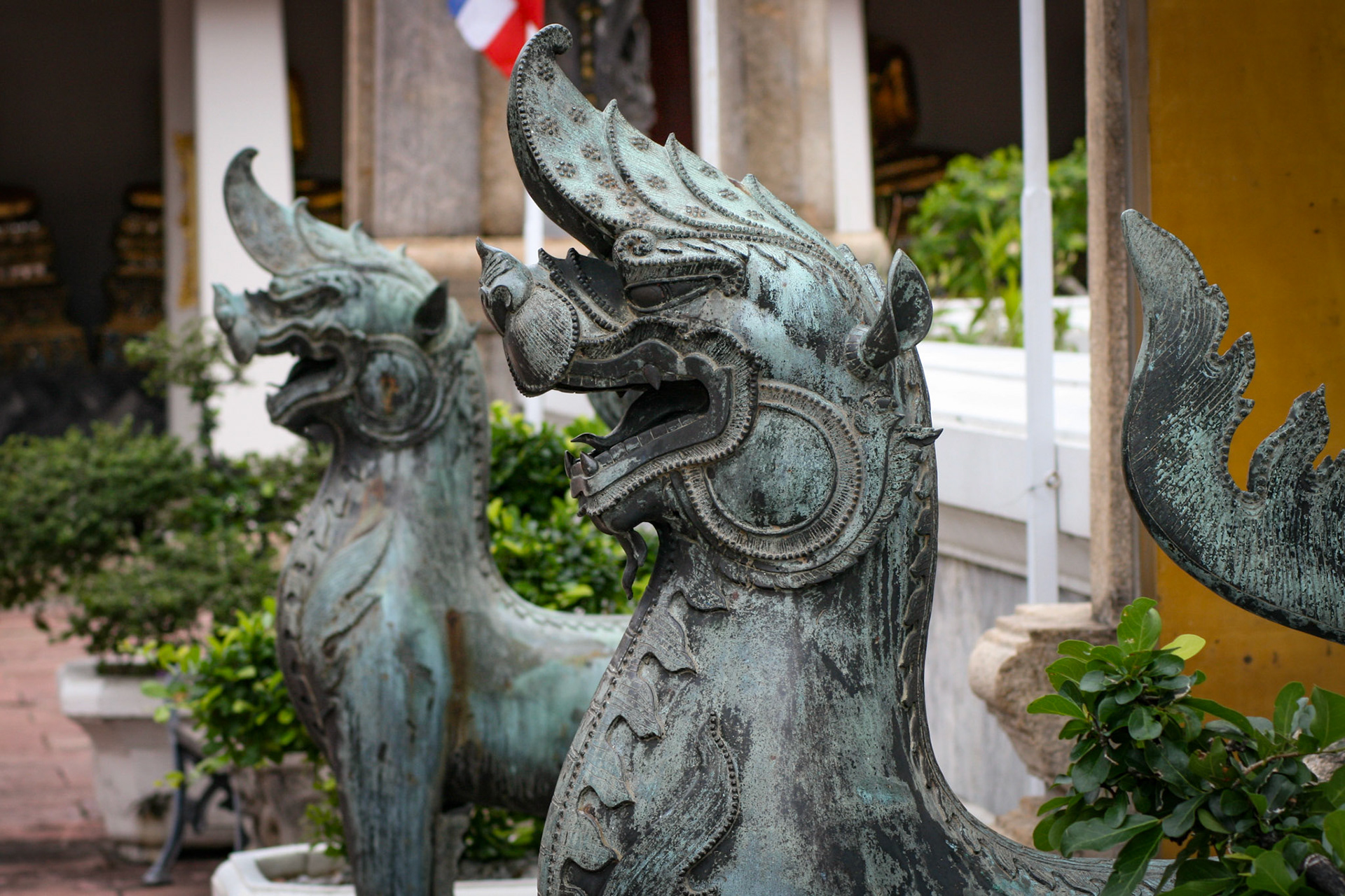 A bronze mythological lion guards the Ubosot