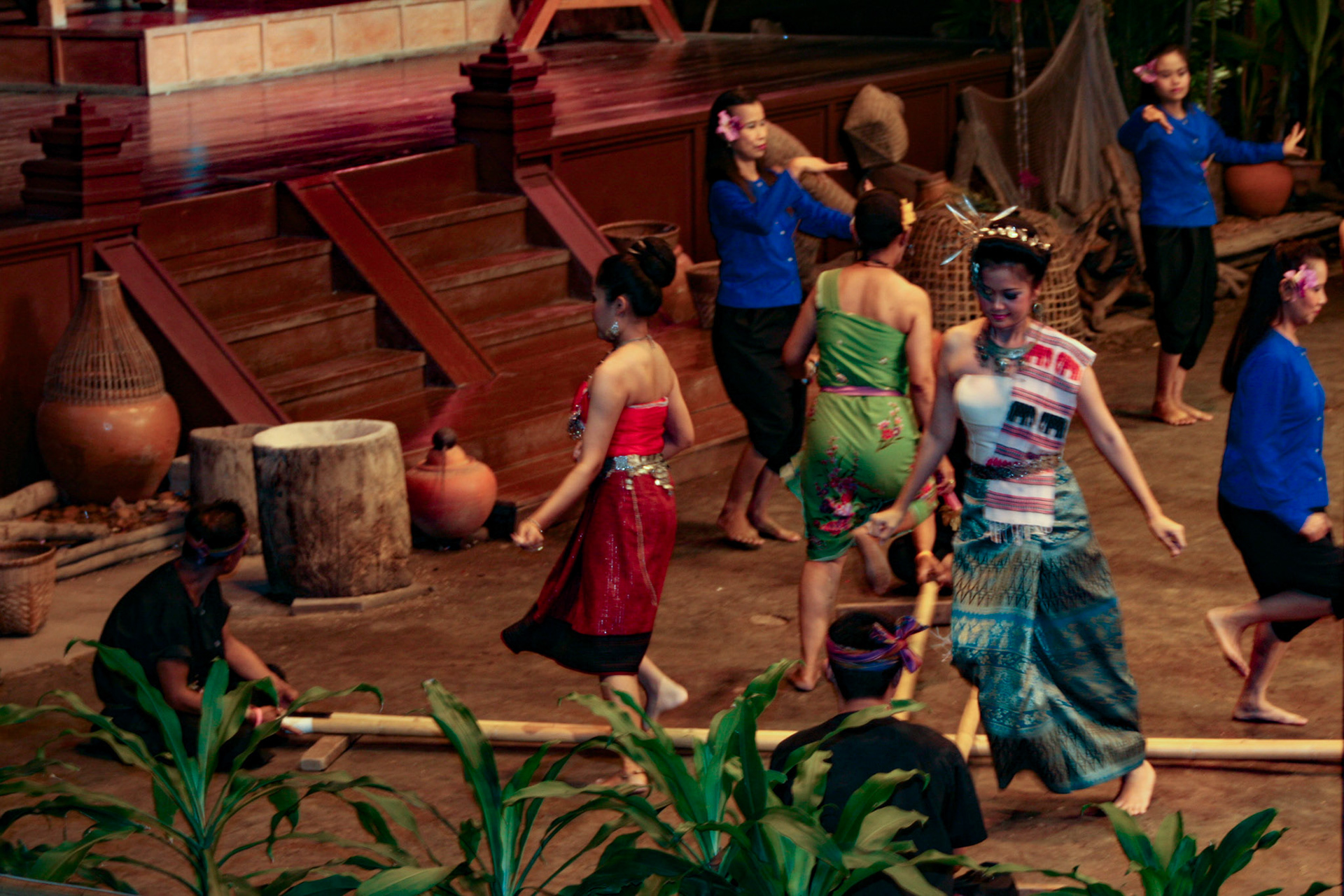 Thai men and women perform the energetic Bamboo Dance of northeastern Thailand at the Rose Garden