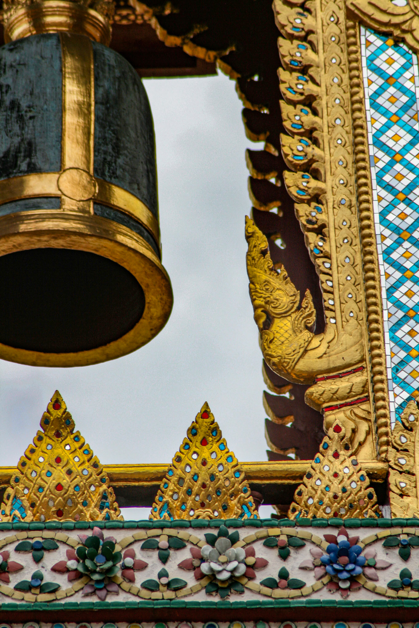 A Thai traditional bell tower (belfry) with detailed, mosaic artwork and gold colored design at Wat Phra Kaew (Temple of the Emerald Buddha) at the Grand Palace