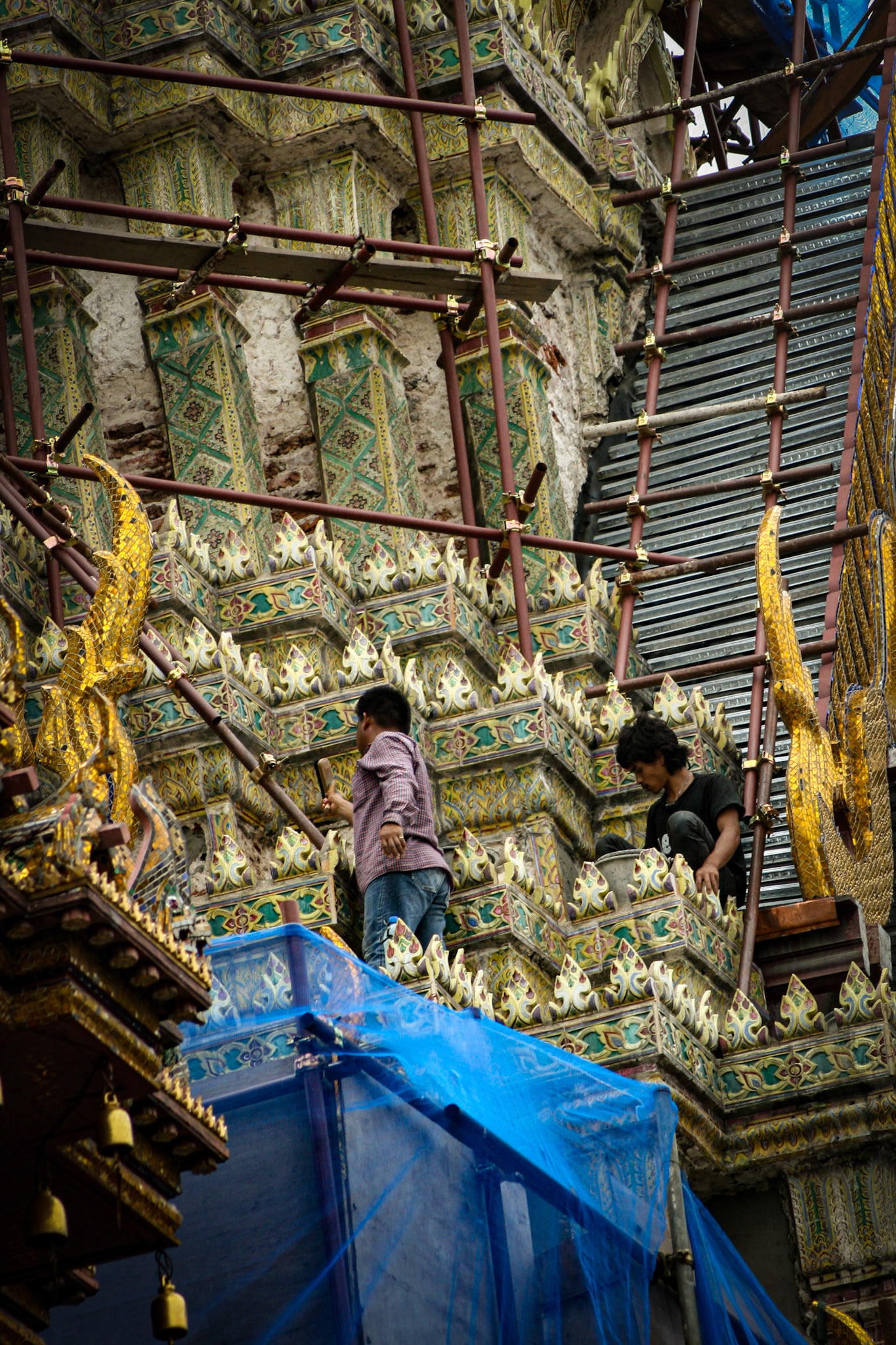 Workers clean the tilework of the building rooflines.