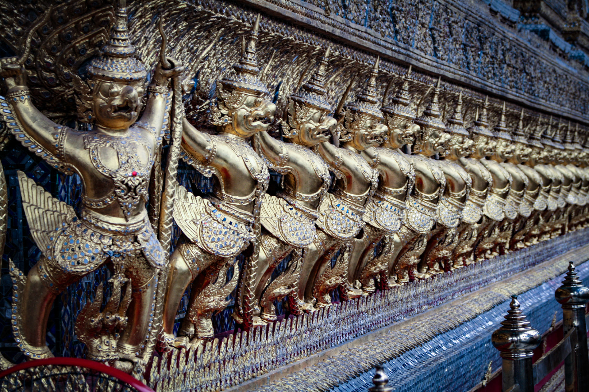 Golden garuda and naga statue, decoration on a wall of The Emerald Buddha temple, Wat Phra Kaew, Grand Palace, Bangkok, Thailand. 