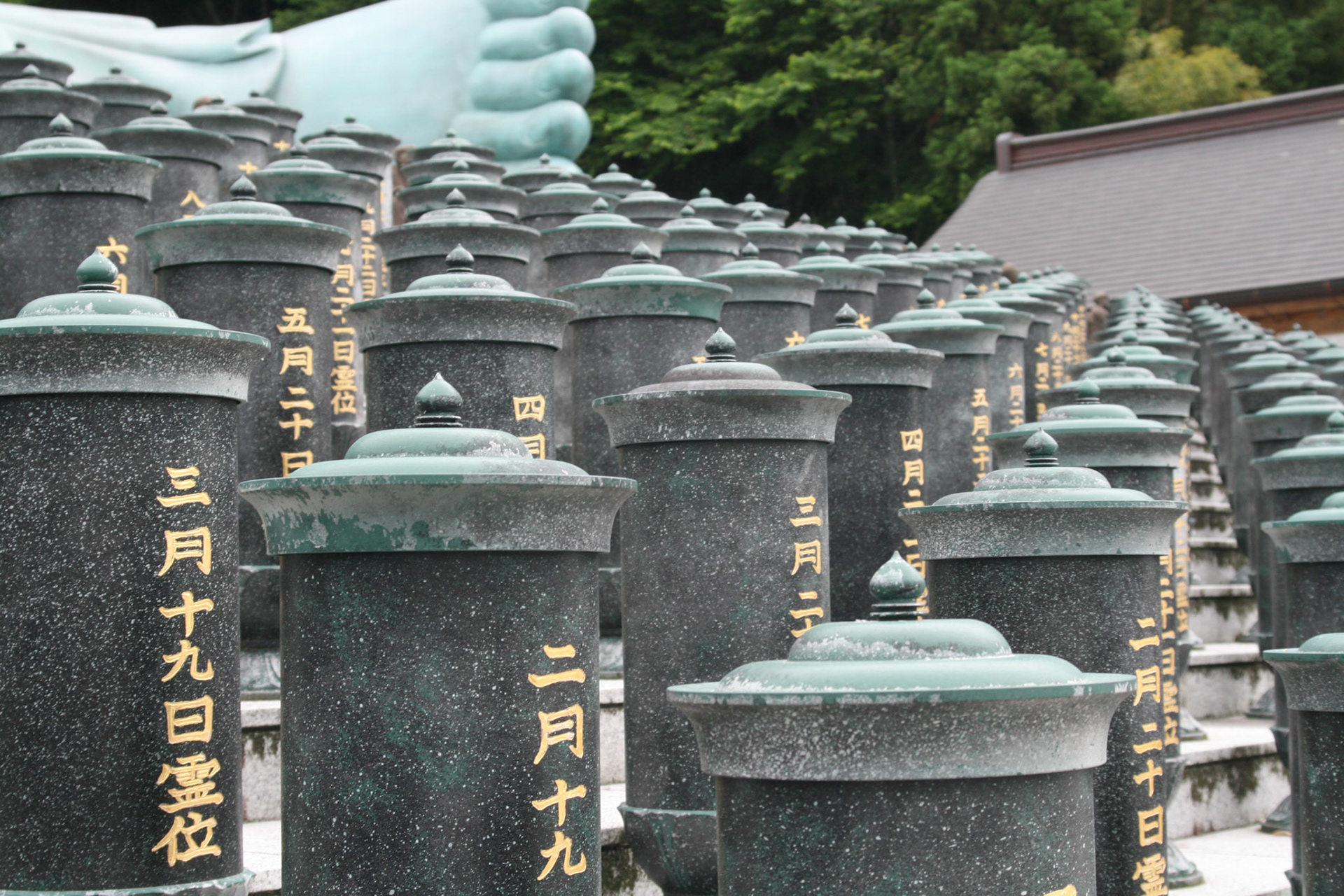 The small columns in front of the statue are nokotsudo where the remains of the deceased are stored. There are said to be 4,315 of these. 