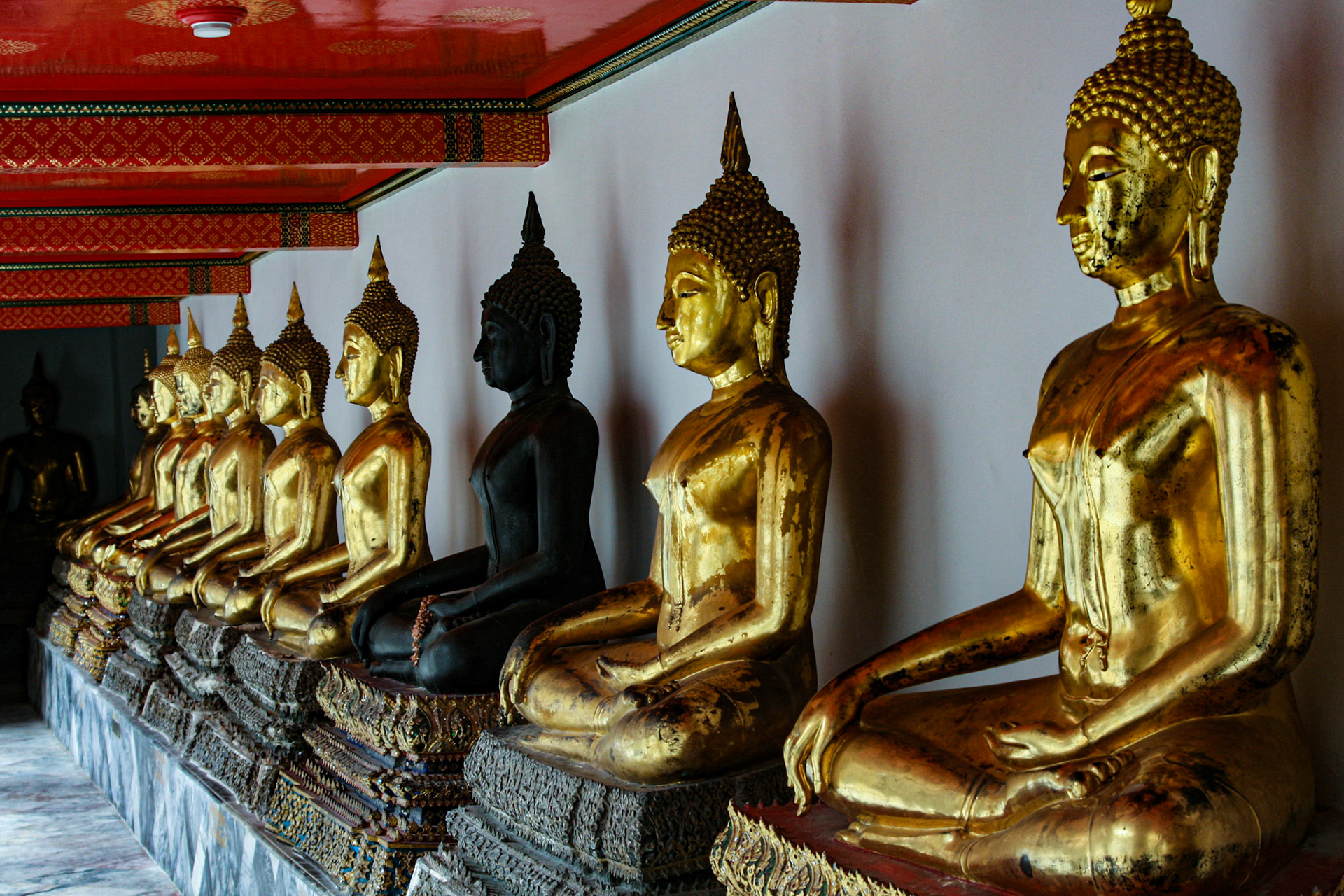 Row of Buddha statues lined up at Wat Pho in Bangkok, Thailand.