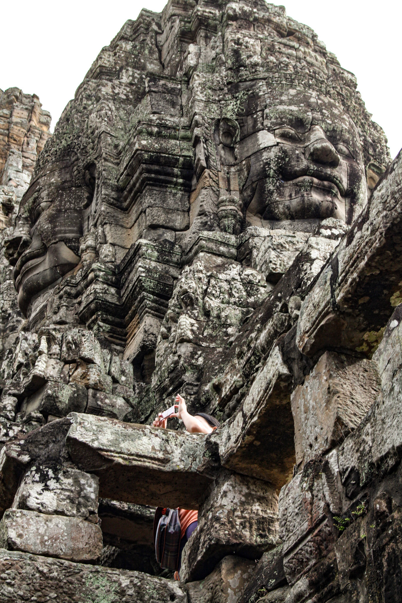The Bayon's most distinctive feature is the multitude of serene and smiling stone faces on the many towers which jut out from the upper terrace and cluster around its central peak. 