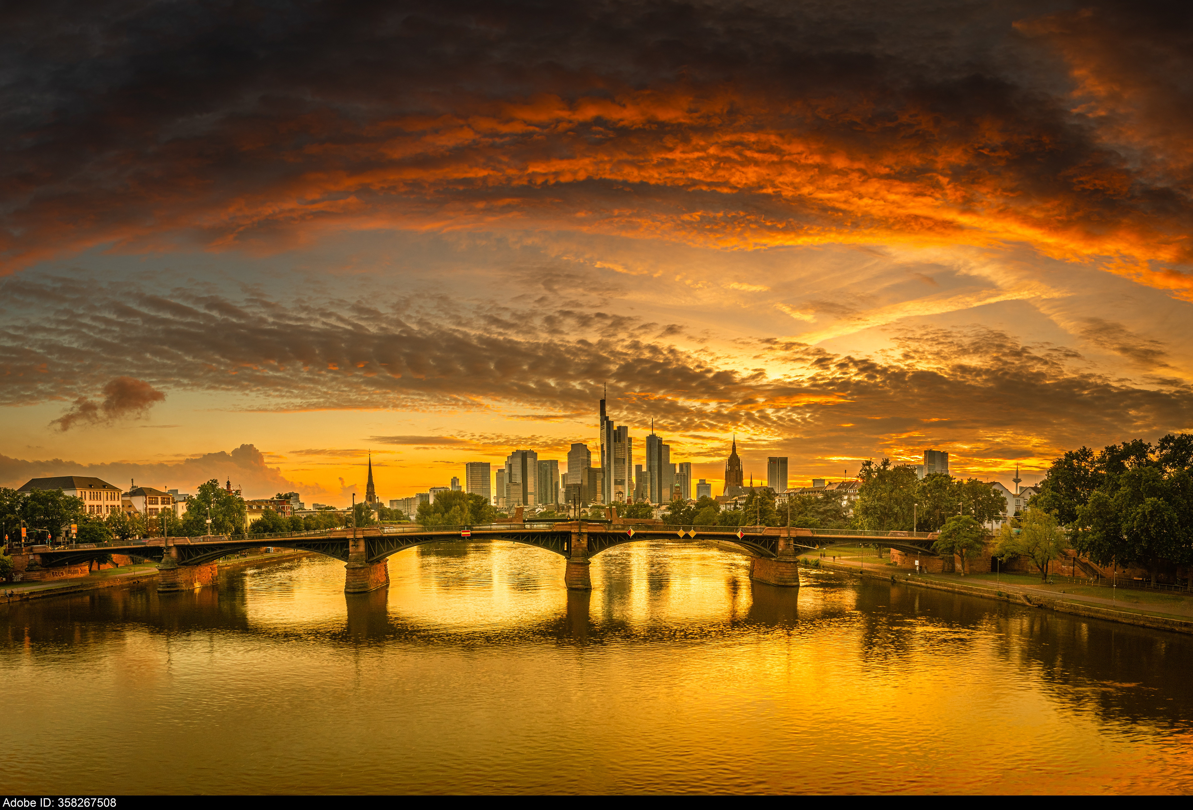 358267508  Hochauflösendes Panorama-Foto der Frankfurter Skyline bei Sonnenuntergang mit einer Brücke über den Main