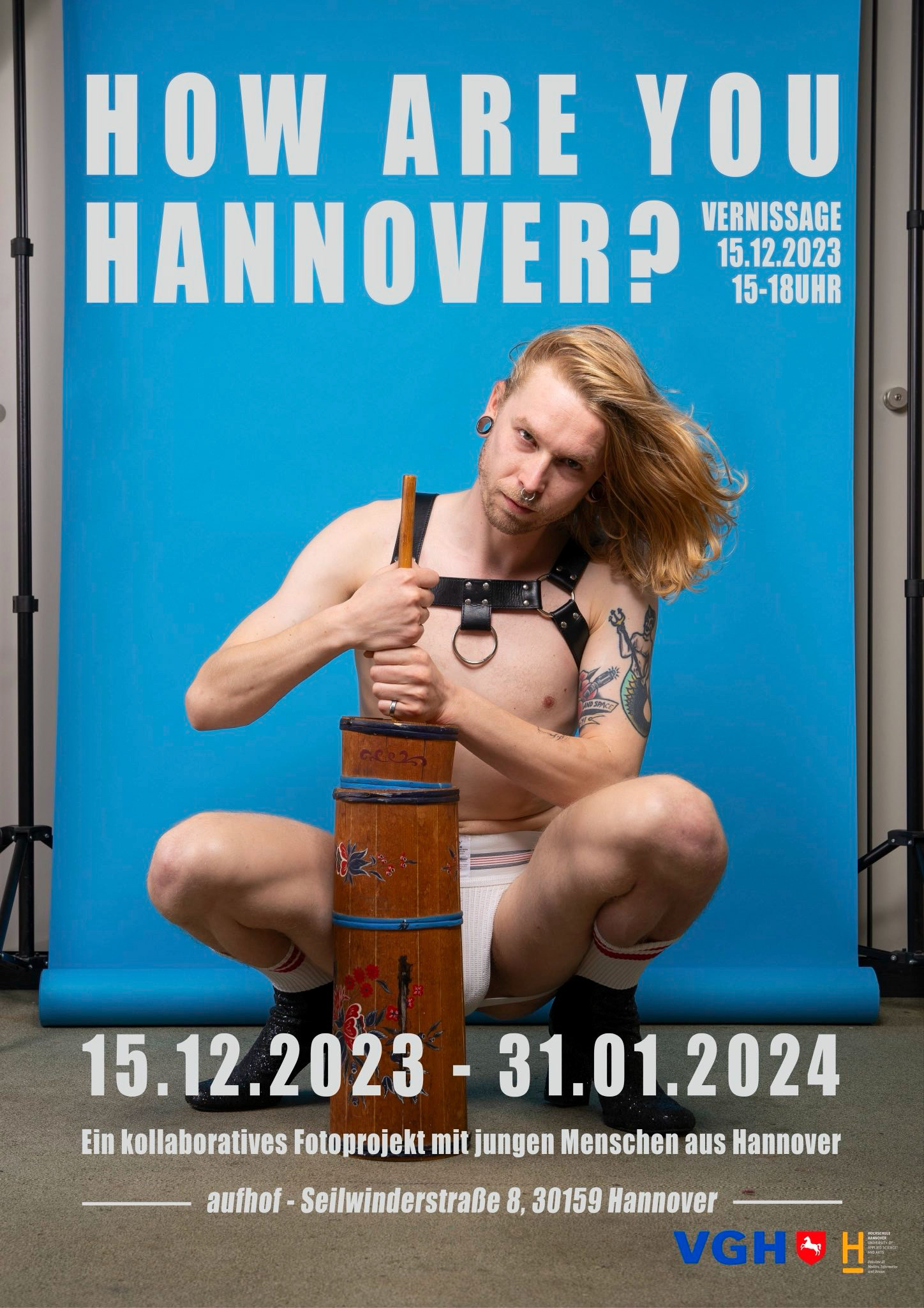 Dieses Plakat zeigt einen jungen Mann, der vor einem blauen Hintergrund kniet und ein Butterfass bedient. Er ist fast nackt und trägt ein Oberkörperharness, ein Jockstrap und schuhe und Socken. Das Plakat wirbt für die Ausstellung How are you Hannover? von Dezember 2023 bis Januar 2024.