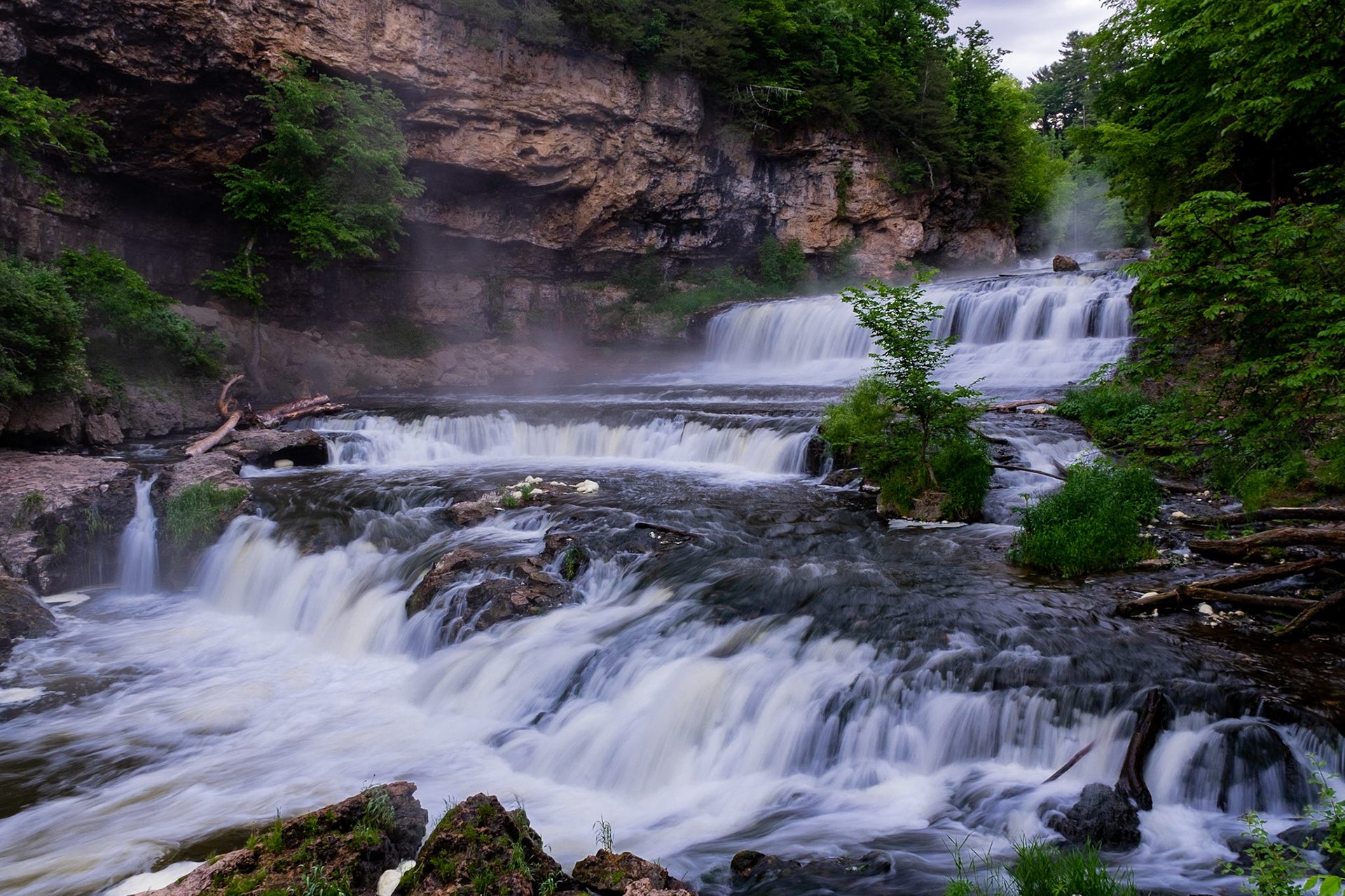 The sun is rising just beyond that rock face in front of me. The winds are coming down river so the it's covering me and my lens... I mean, the mist looks cool as it comes down the river.