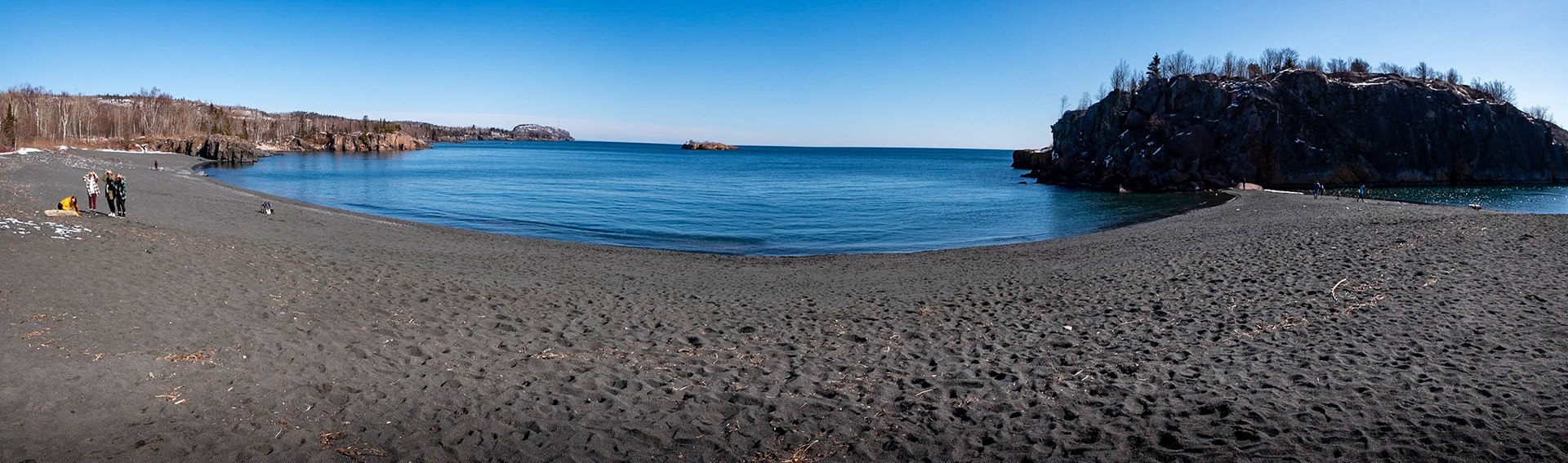 Black Beach - Silver Bay, MN  The black "sand" is from years of taconite being dumped into the waters from mining companies as the waves bring it back to the shore. Over time the waves pound the small rocks into fine pebbles, creating this one of a kind black beach.