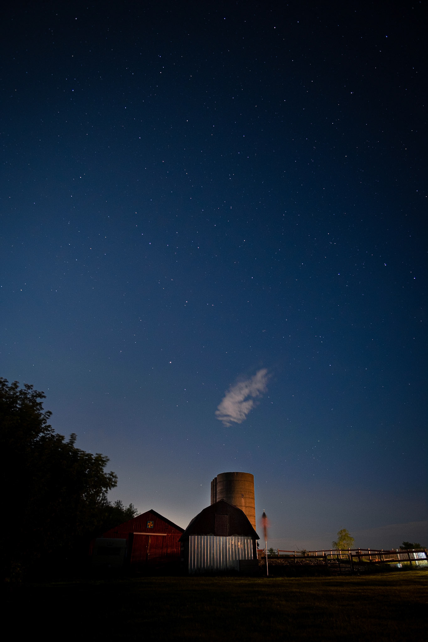 Hey little puff of cloud. You're makin' that silo look like a smoke stack. A look at the pig pen with the night sky.