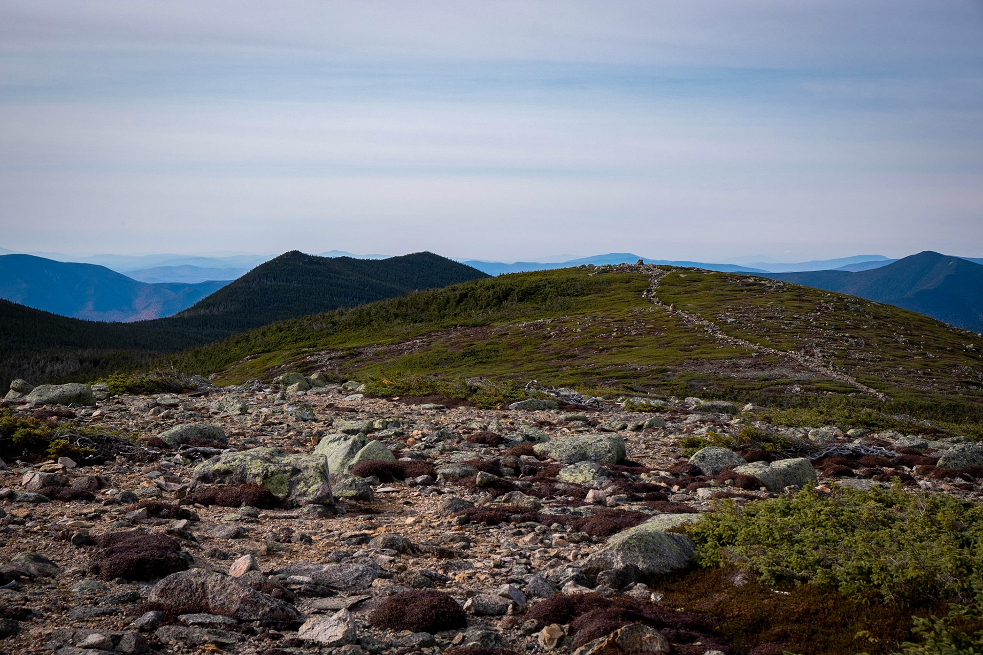 A look ahead to the round mound and then to the twin peaks and down into the valley. Follow the trail of rocks! 4491.5 ft
