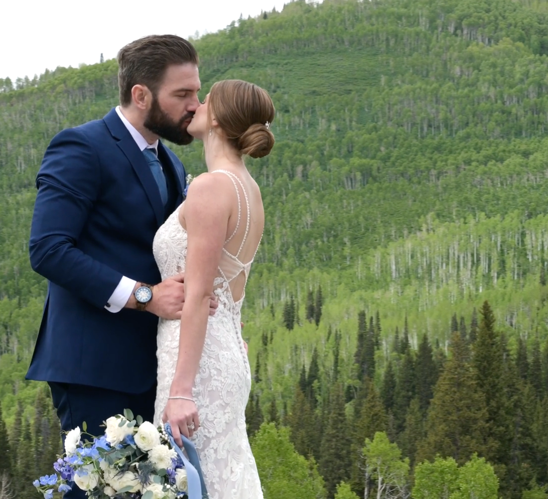 Husband and wife kissing with forest background