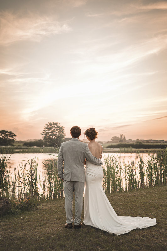 Natalia and Daniel share a hug while looking out across the lake at Brackenborough Lakes Resort in Louth, surrounded by the warm glow of a summer sunset.