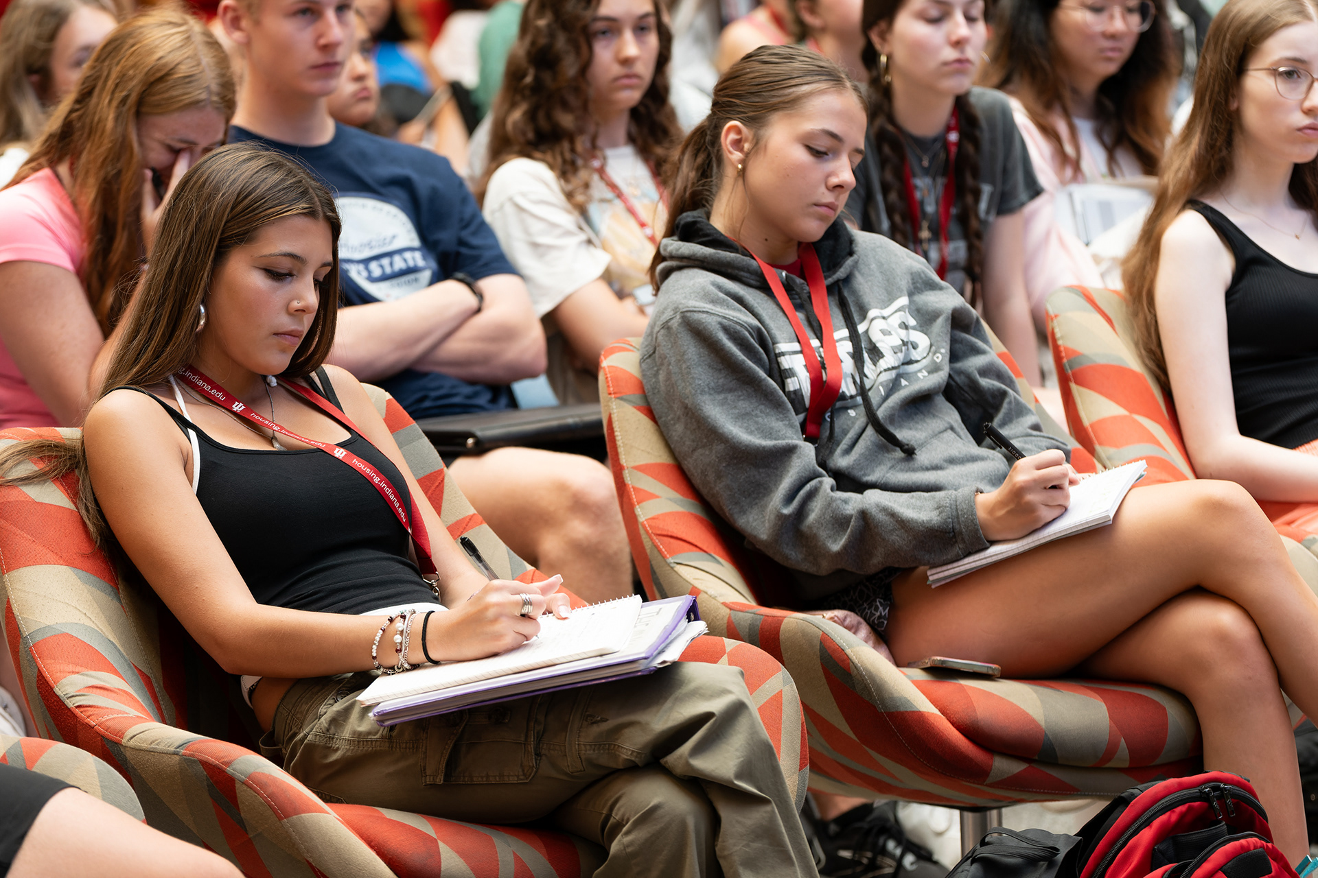 Indiana University High School Journalism Institute students Olivia Brown, of San Diego, Calif., and Bailey Basham, of Mt. Washington, Ky., write notes during a lecture on reporting fundamentals in Franklin Hall, Tuesday, July 9, 2024, in Bloomington, Ind. (Vincent Hsiao/HSJI)