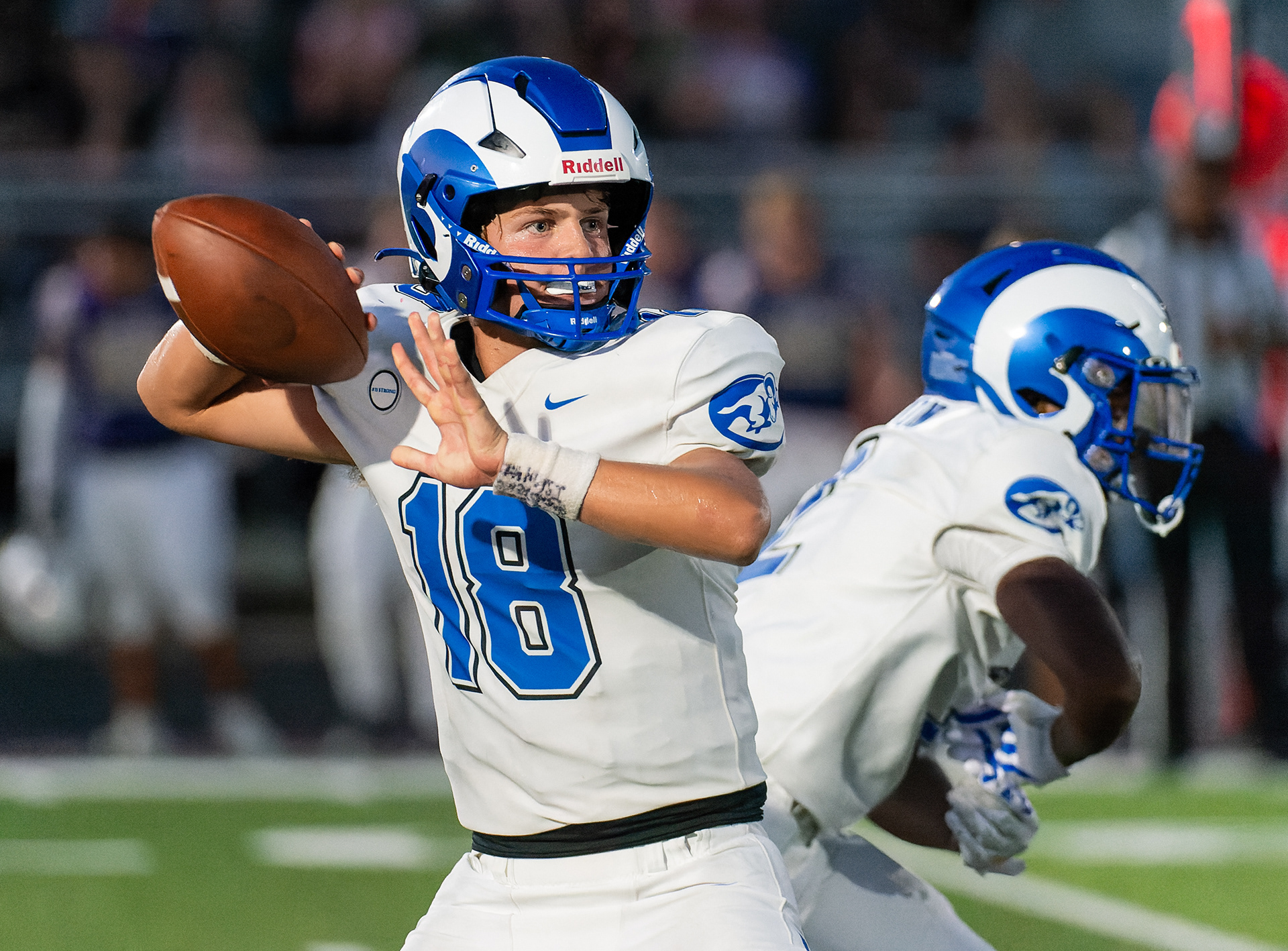 Ladue quarterback Jack Hensley (11) winds up for a pass as running back Marco Tipton (10) fakes the handoff during the varsity football season-opener against Troy Buchanan High School, Thursday, Aug. 29, 2024, in Troy, Mo. The Troy Buchanan Trojans beat the Ladue Rams 48-20.