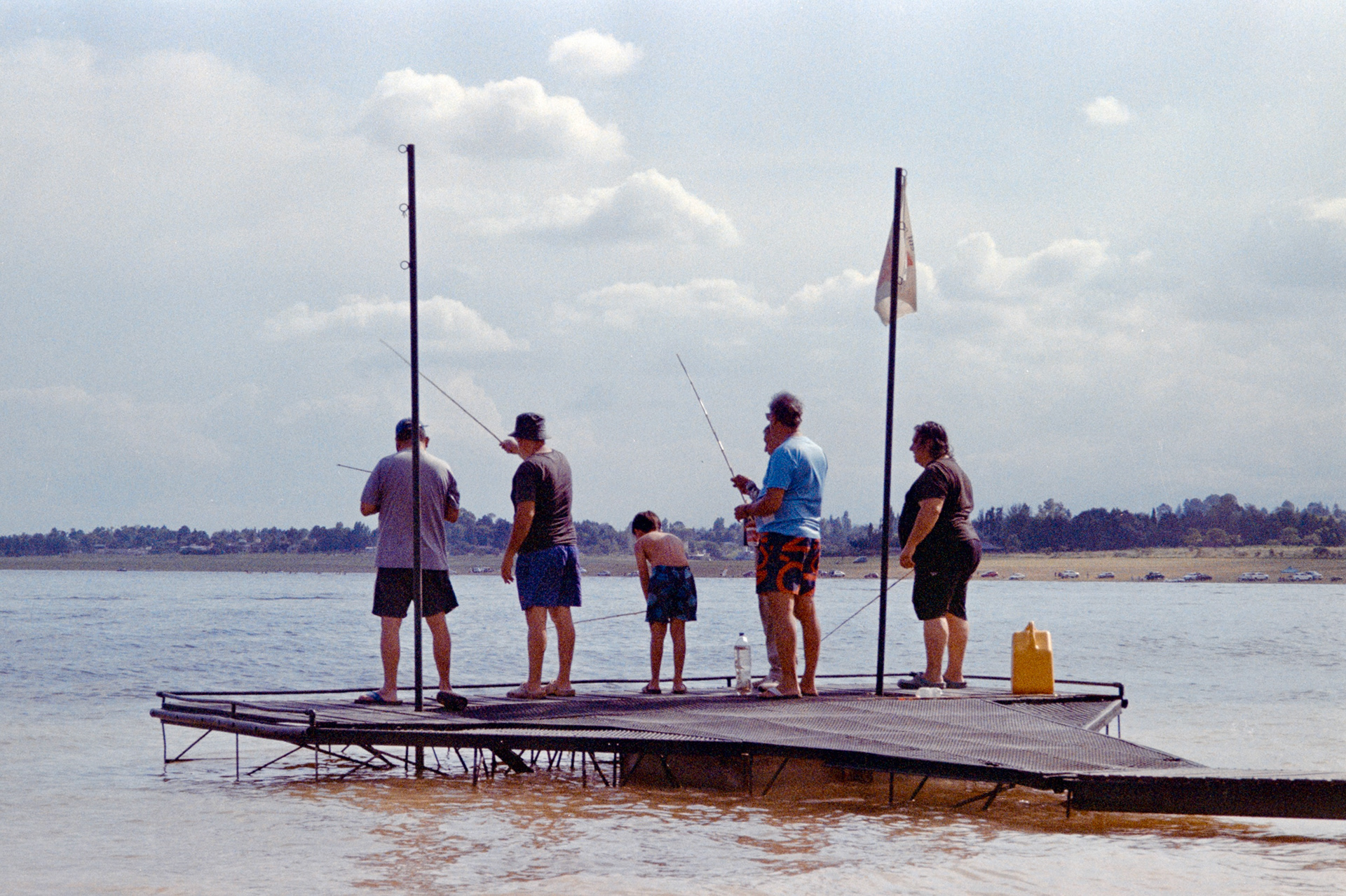 A kid fishing with four middle aged men. Dique Los Molinos, Córdoba, Argentina. December 2024.