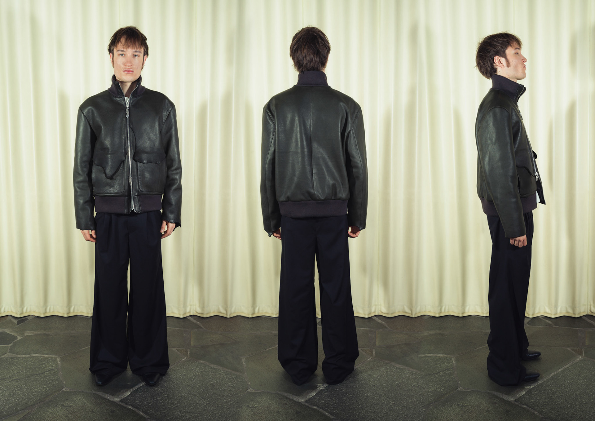 Raw edge calfskin leather jacket with handmade silver zipper tabs, Cotton poplin henley shirt with handmade ceramic buttons, Pleated wide-leg pinstripe wool trousers