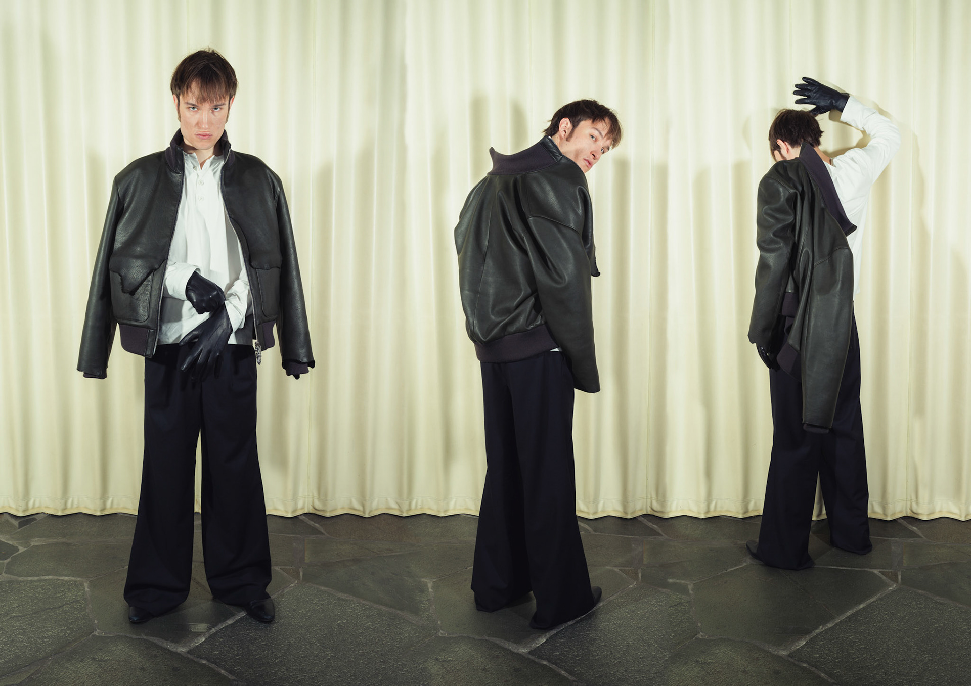 Raw edge calfskin leather jacket with handmade silver zipper tabs, Cotton poplin henley shirt with handmade ceramic buttons, Pleated wide-leg pinstripe wool trousers