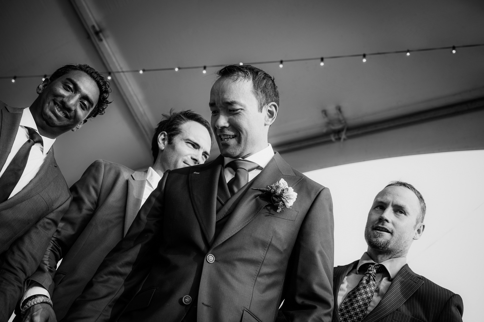 Groom with groomsmen sharing a candid laugh before the reception.
