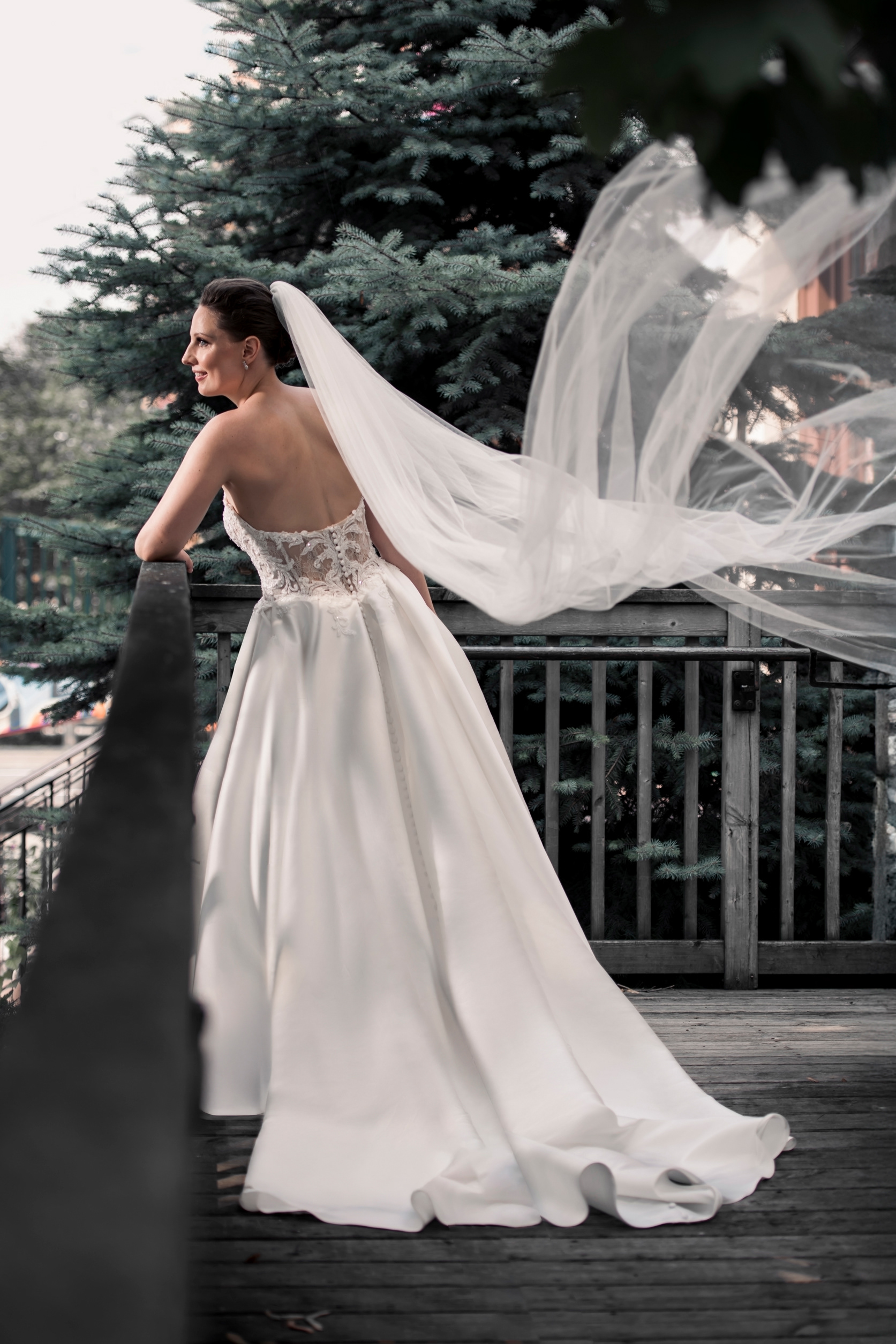 Bride standing on a terrace with her veil blowing in the wind at Palais Royale.