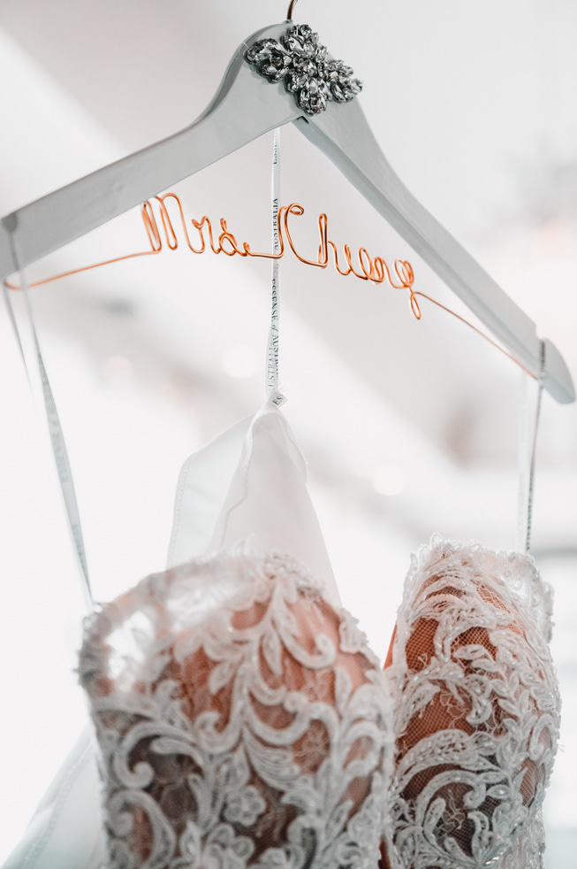 Bride’s dress hanger reading “Mrs. Cheong” in copper wire.