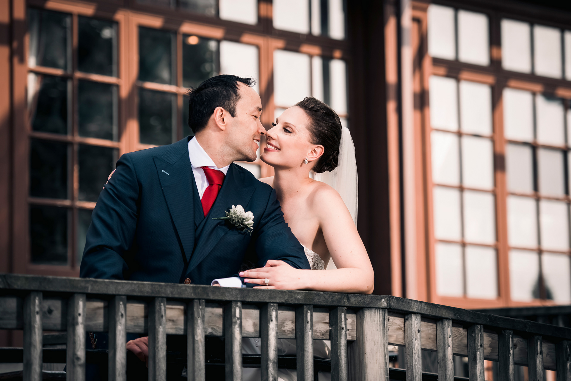 Bride leaning against groom on wooden balcony outside Palais Royale.