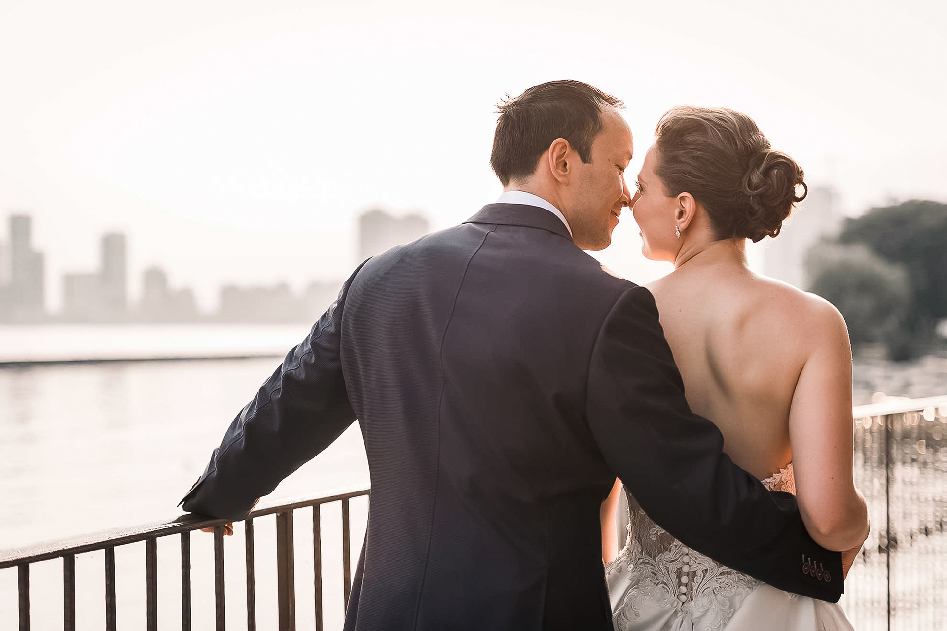 Bride and groom walking arm in arm along the Palais Royale terrace at sunset.