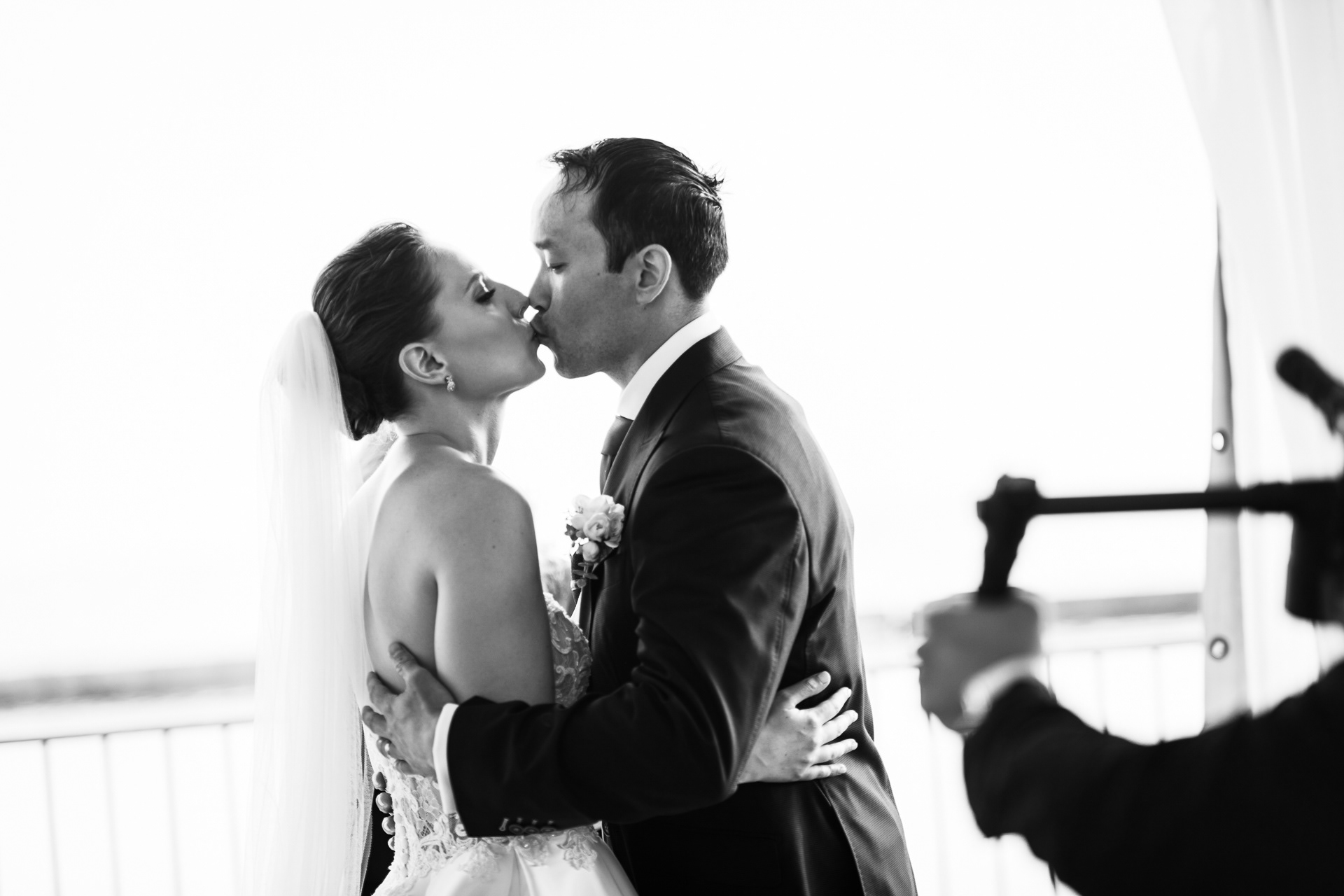 Bride and groom sharing a kiss during their waterfront ceremony.