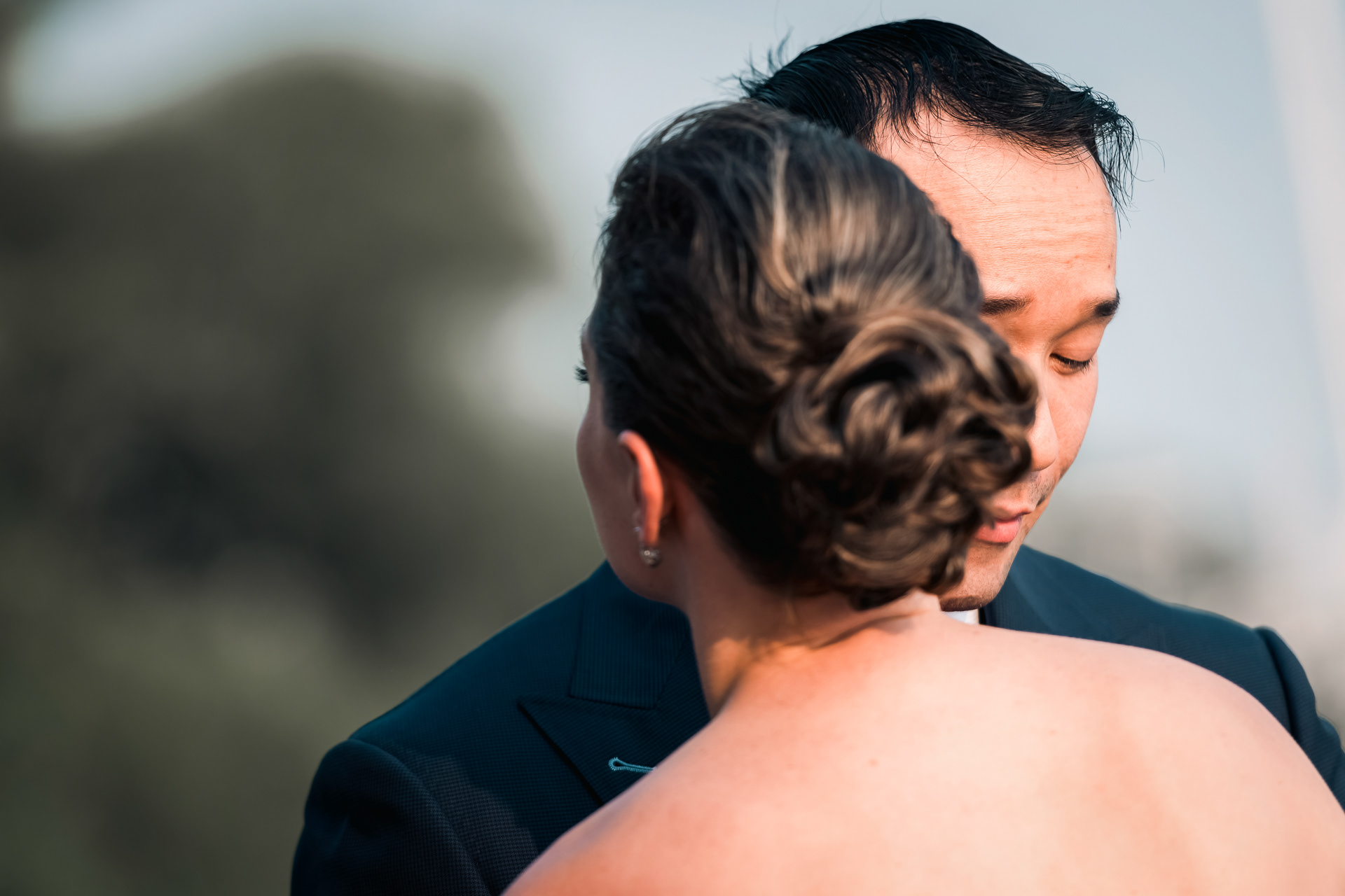 Intimate moment of bride and groom embracing outdoors.