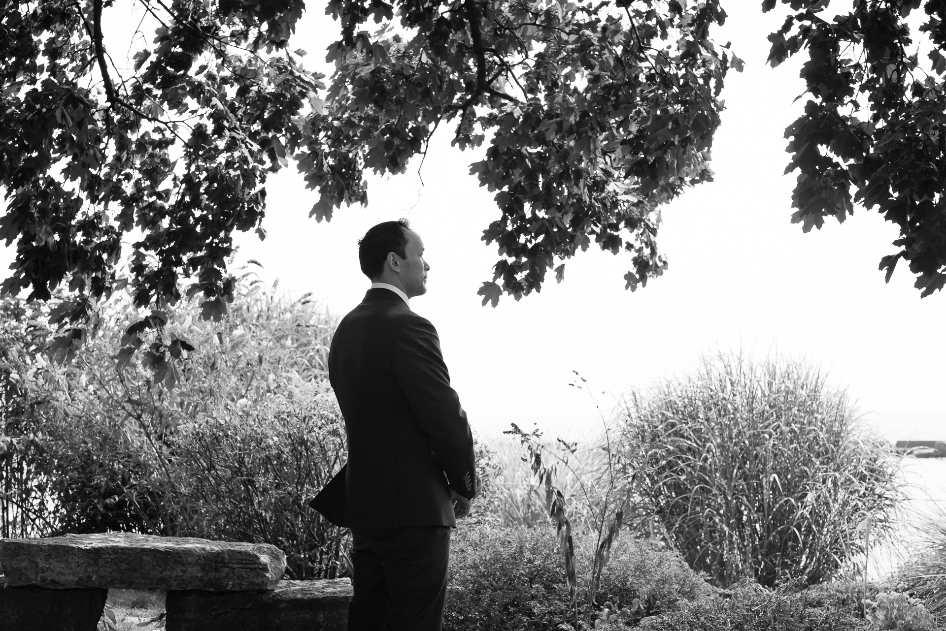 Groom waiting under the trees before first look.