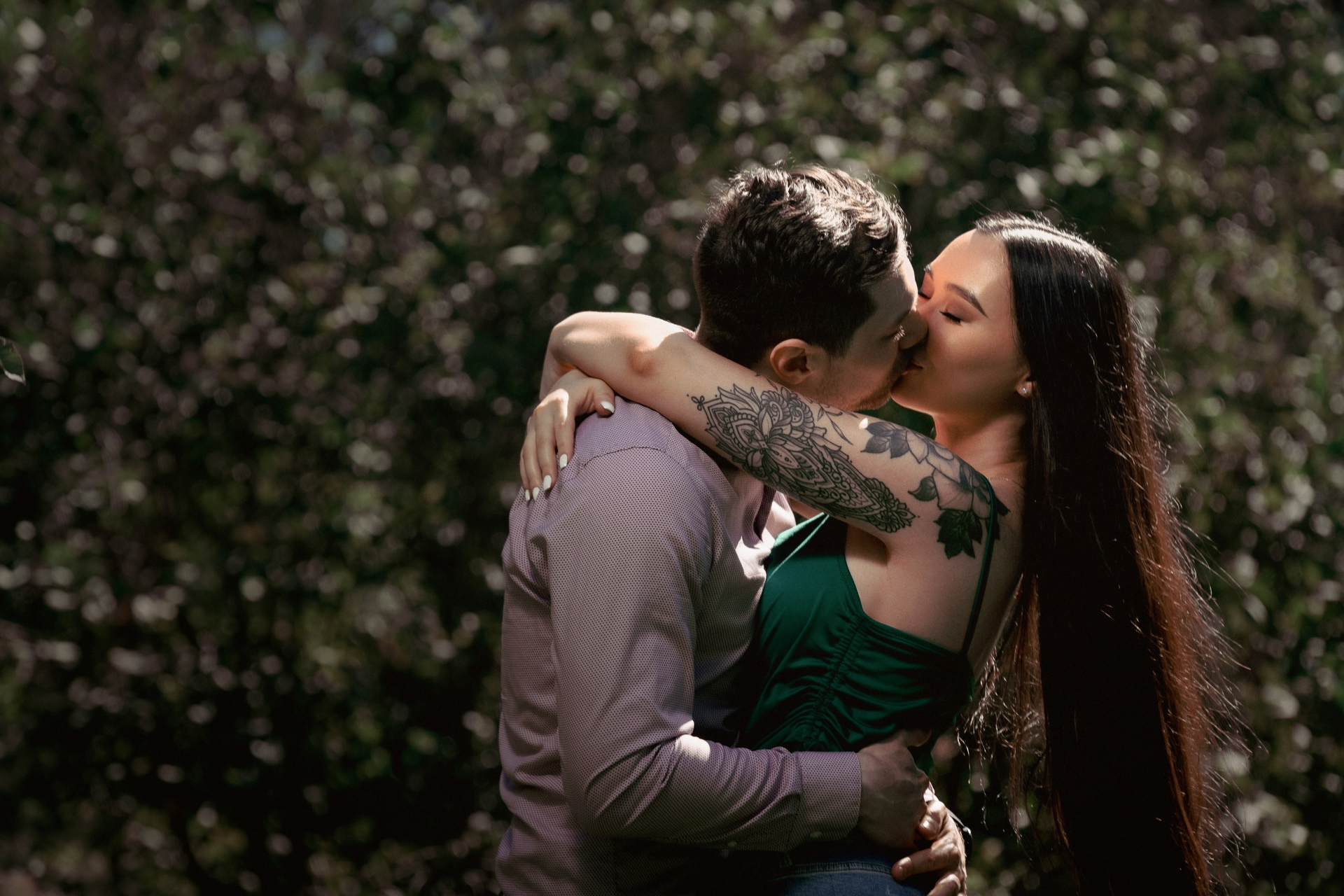 Romantic kiss after proposal, couple holding each other tightly in the garden.
