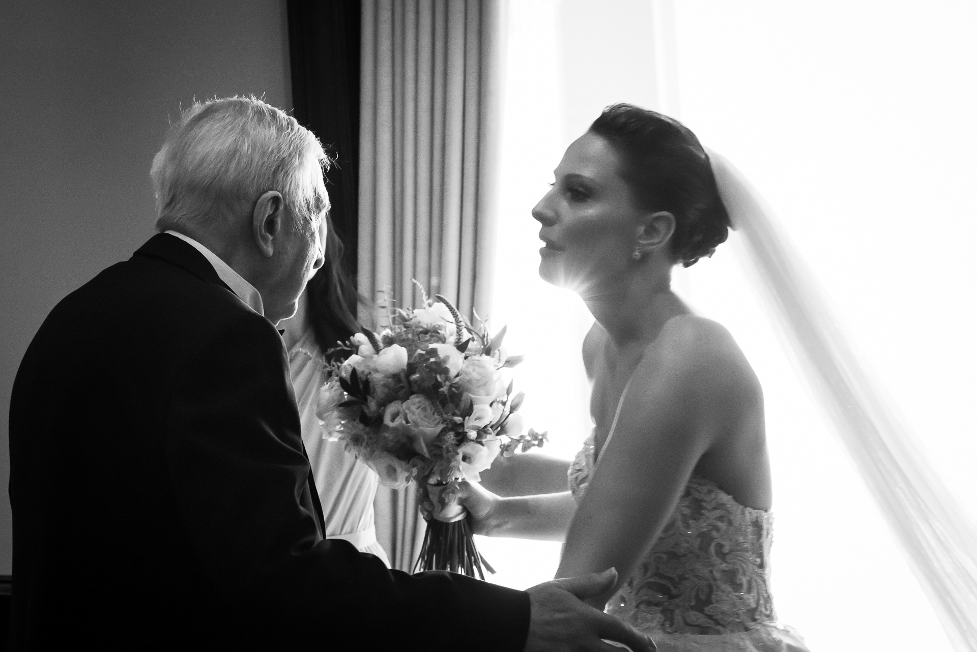 Emotional black and white moment between bride and her father before ceremony.