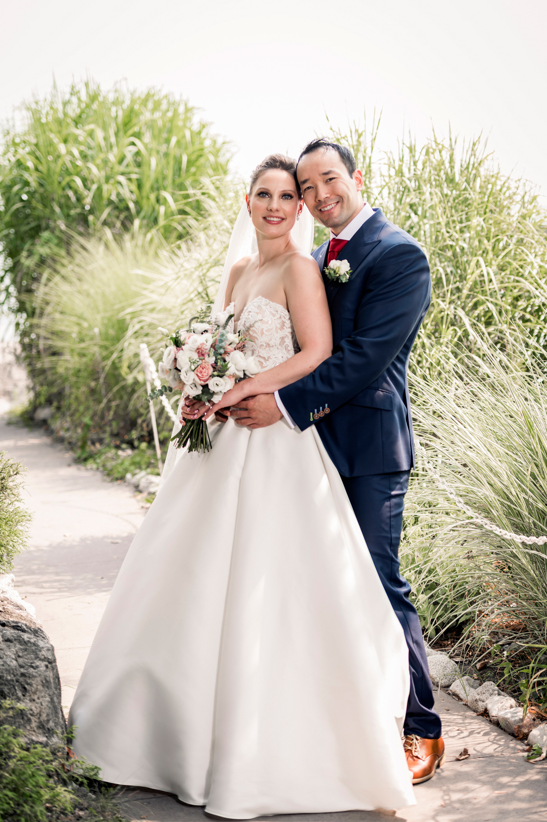 Bride and groom smiling together during their Palais Royale garden portraits.