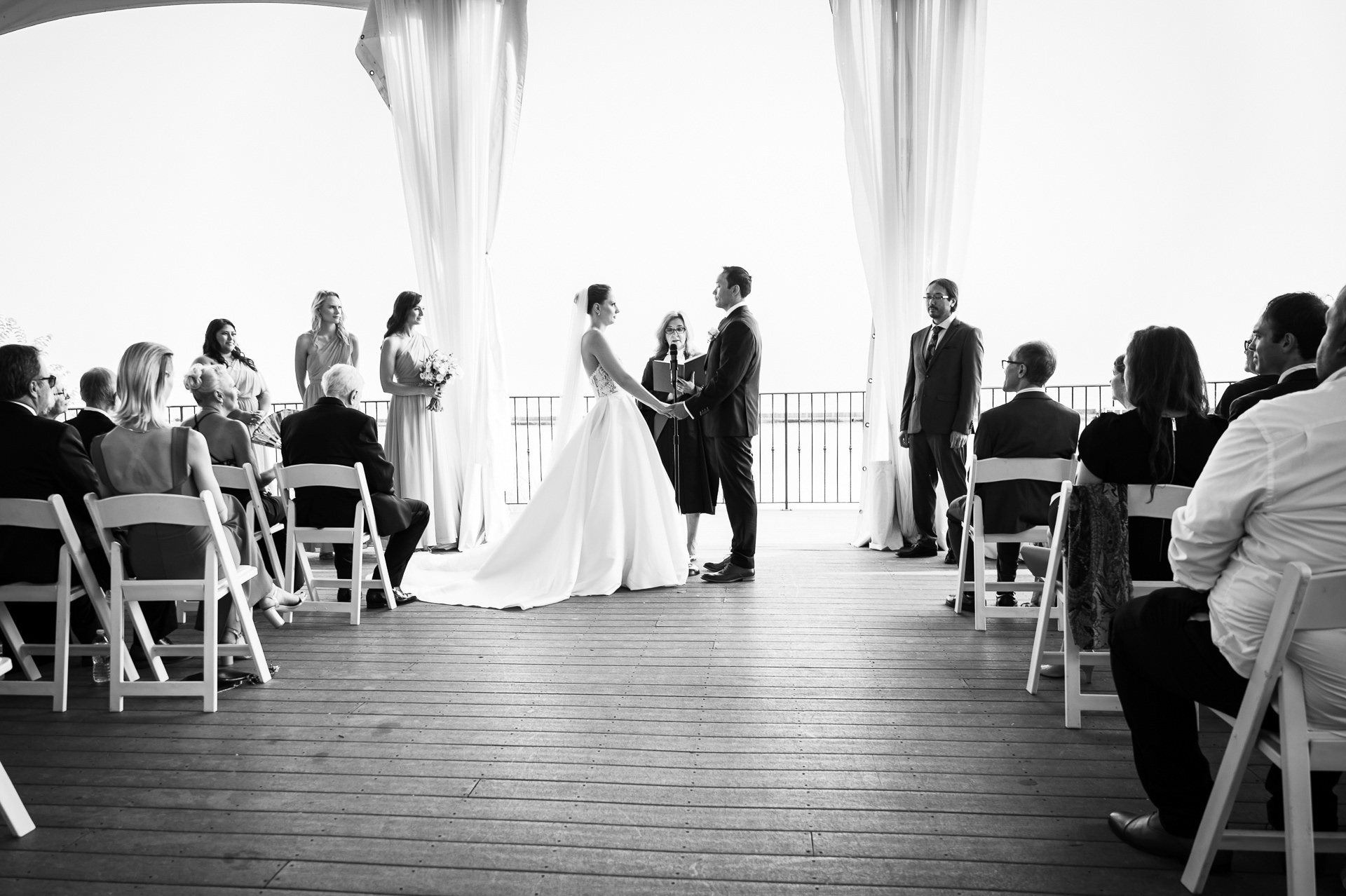 Bride and groom exchanging vows during their Palais Royale wedding ceremony, with guests watching.