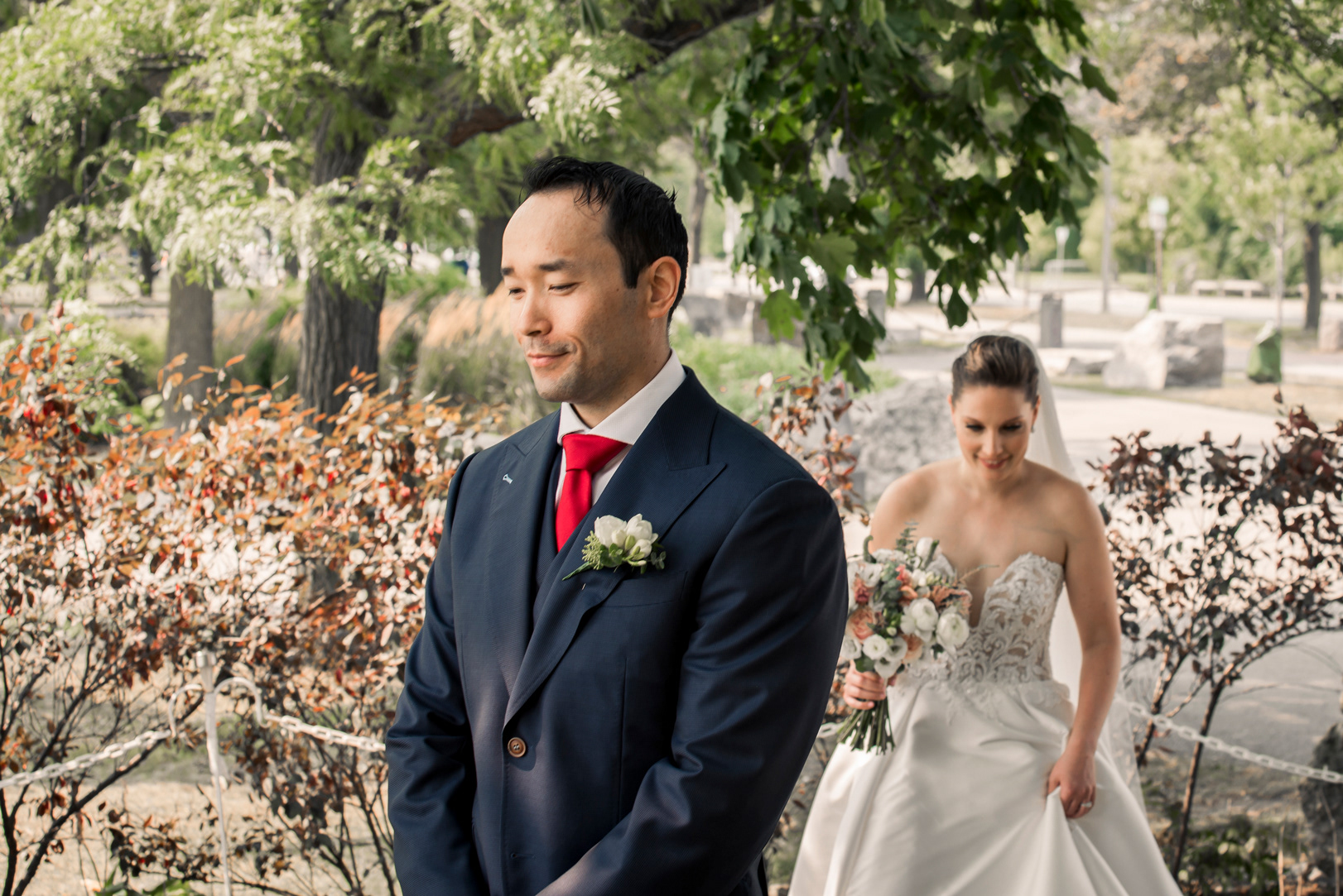 Groom smiling nervously as bride approaches.