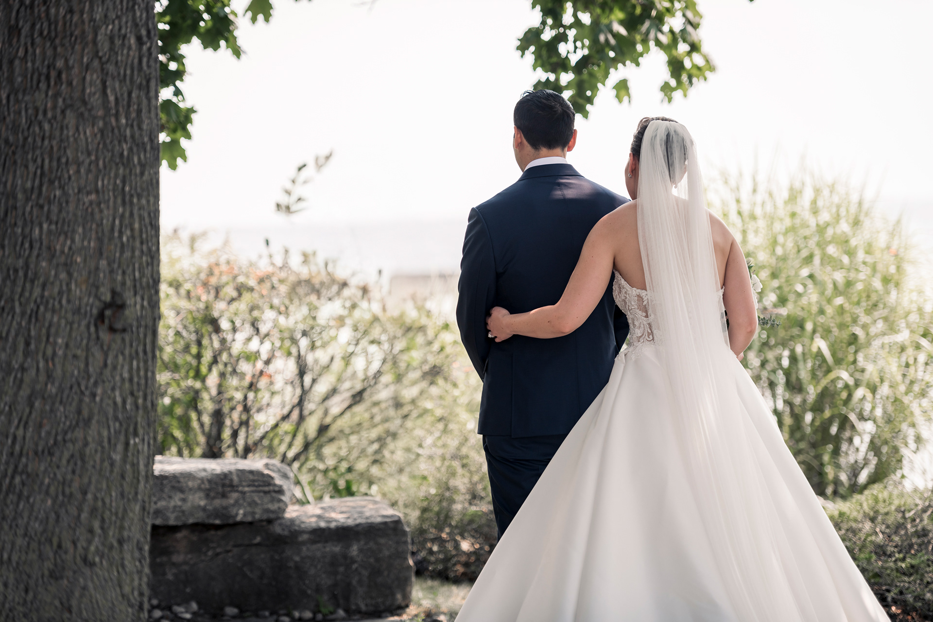 Bride and groom sharing a private first look under the trees at Palais Royale.