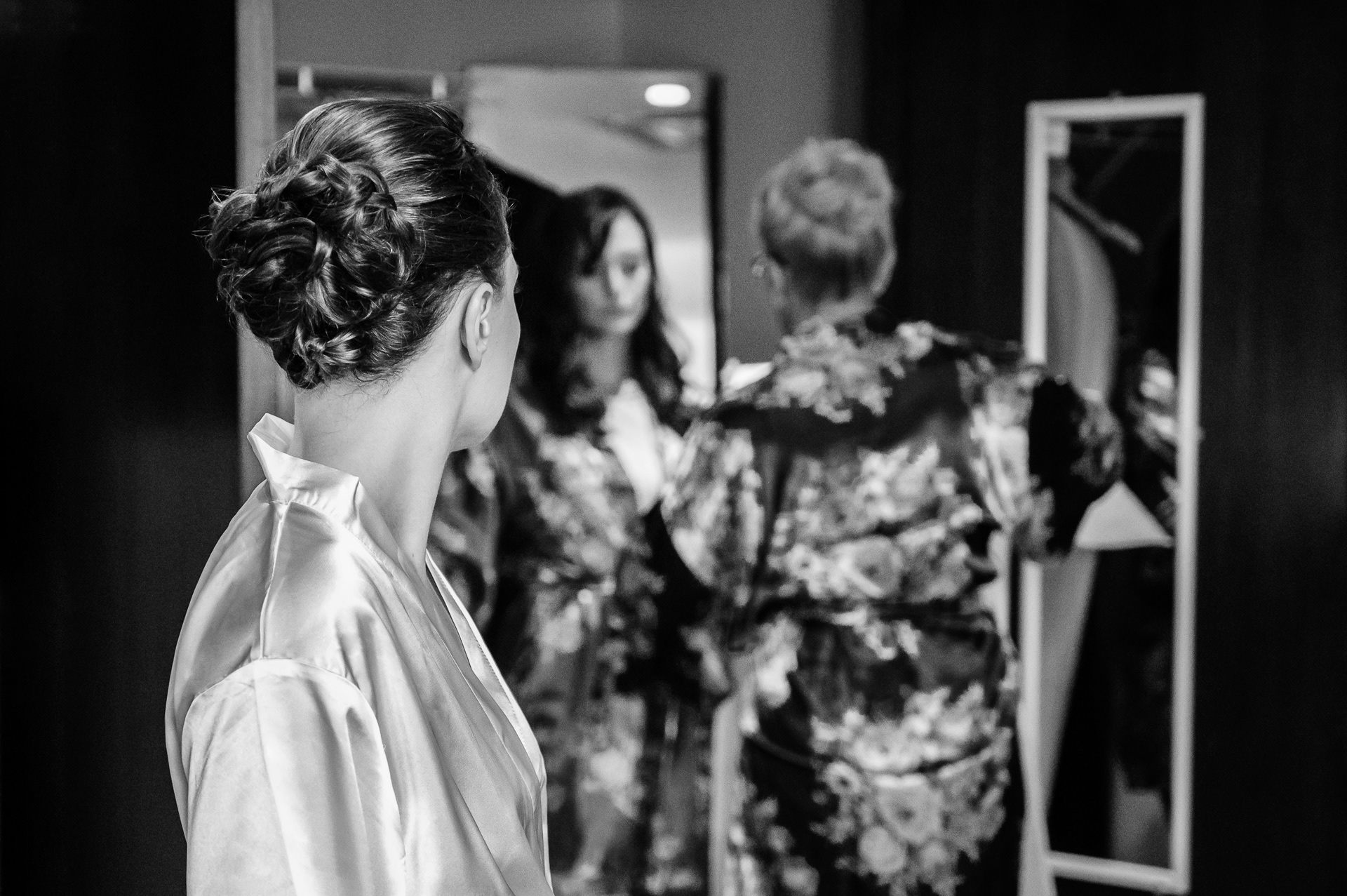 Bride looking at her bridesmaids while getting ready.