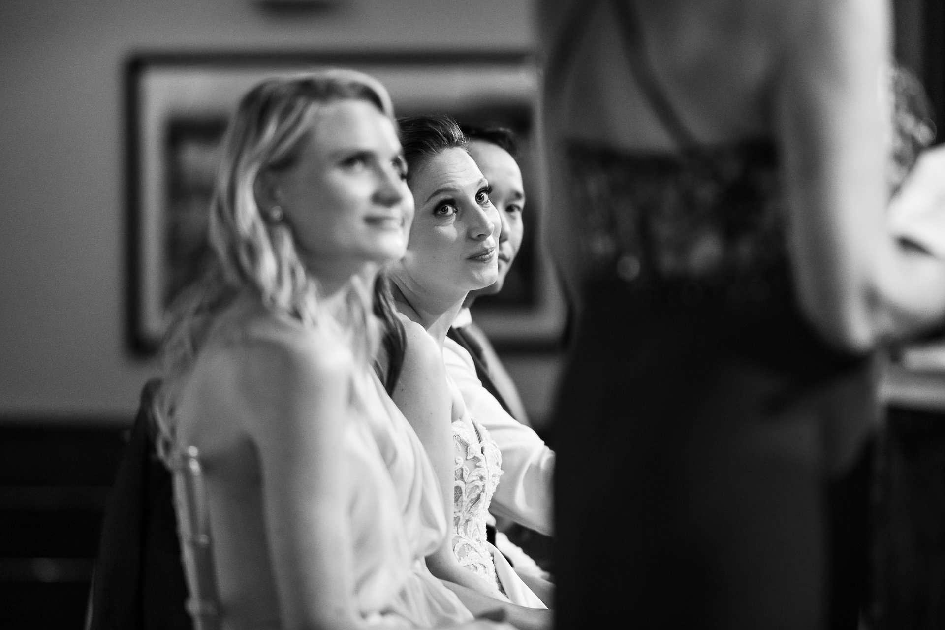 Black and white candid of the bride having an emotional moment during wedding speeches at Palais Royale.