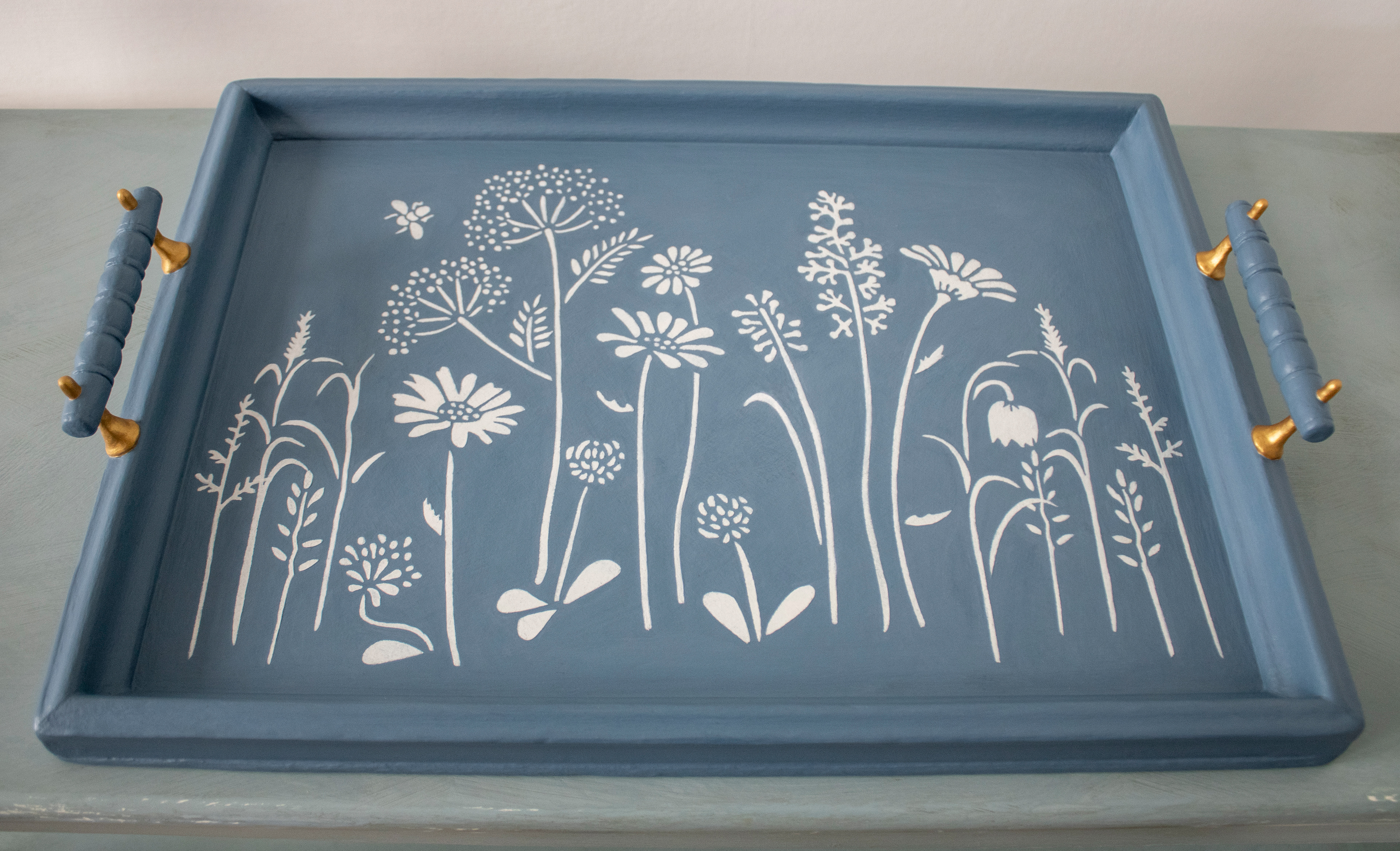 Vintage wooden tray hand painted with decorative flower stencil. Hand painted with Shabby Chic Cottage Blue, Antique Gold and Annie Sloan Old White chalk paint.  48cm Long (including handles), 33 cm Wide, 7cm High (including handles).