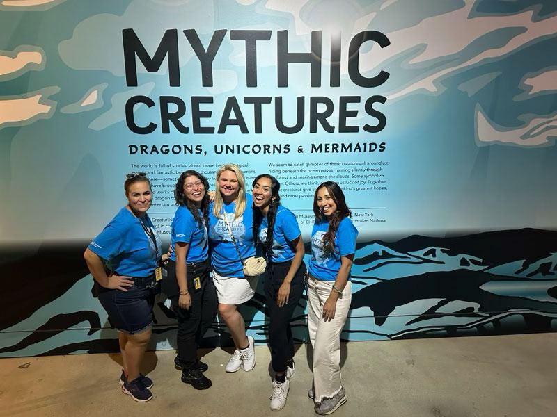 The marketing team wearing the Mythic Creatures staff shirt at opening day